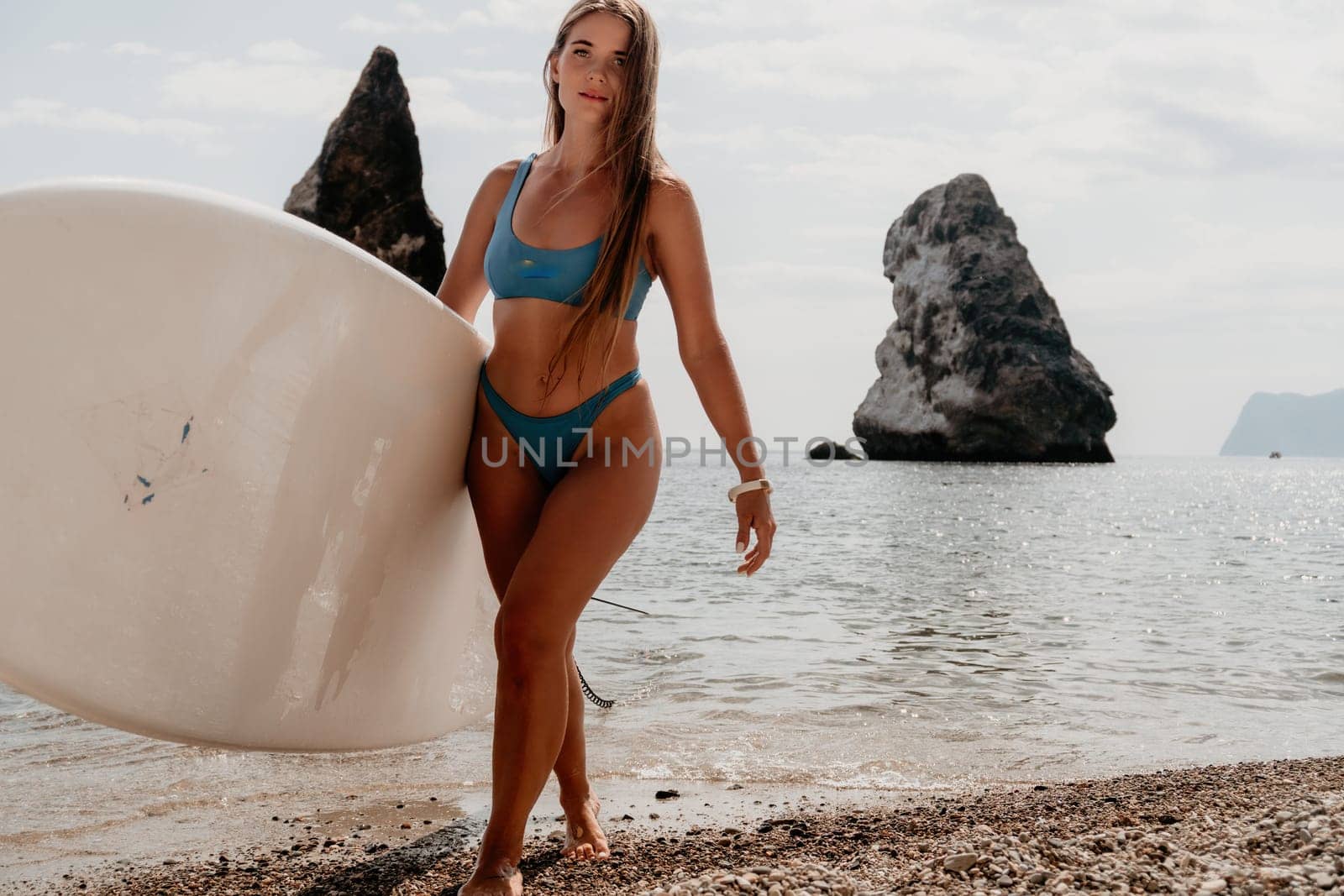 Woman sea sup. Close up portrait of happy young caucasian woman with long hair looking at camera and smiling. Cute woman portrait in bikini posing on sup board in the sea by panophotograph