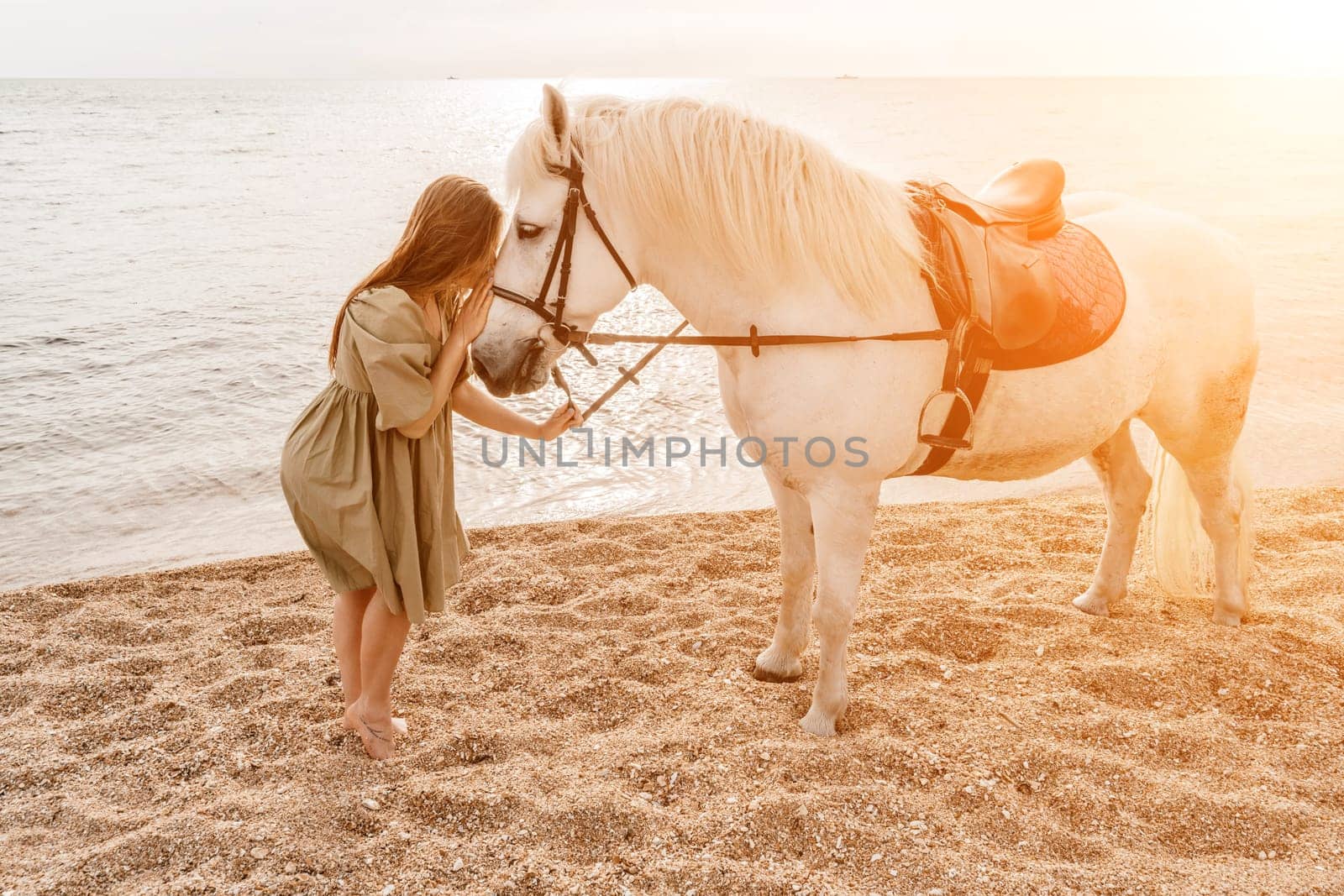 A white horse and a woman in a dress stand on a beach, with the by Matiunina