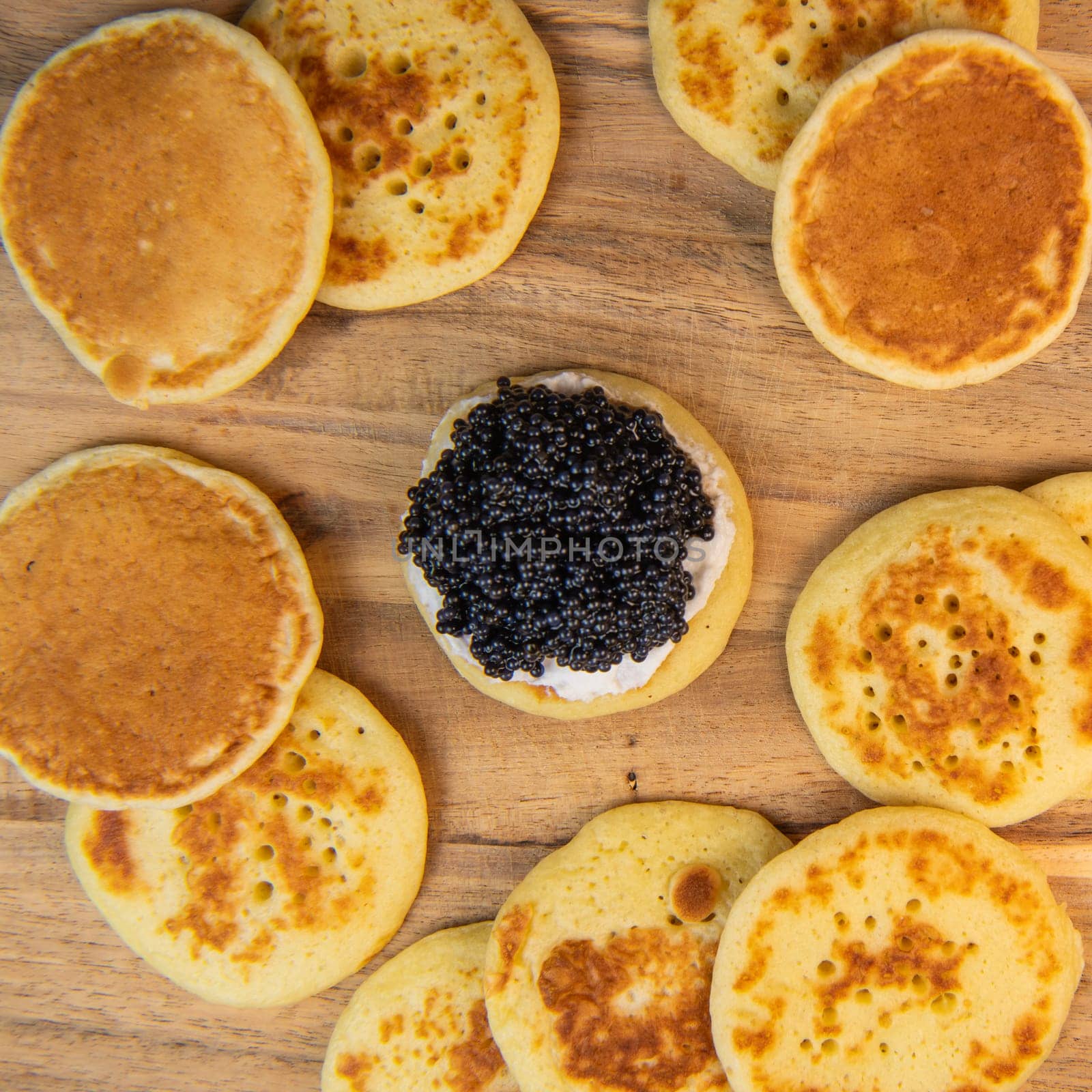 Blinis with black caviar and cream cheese, on a festive dish, mini pancakes, an elegant appetizer, High quality photo
