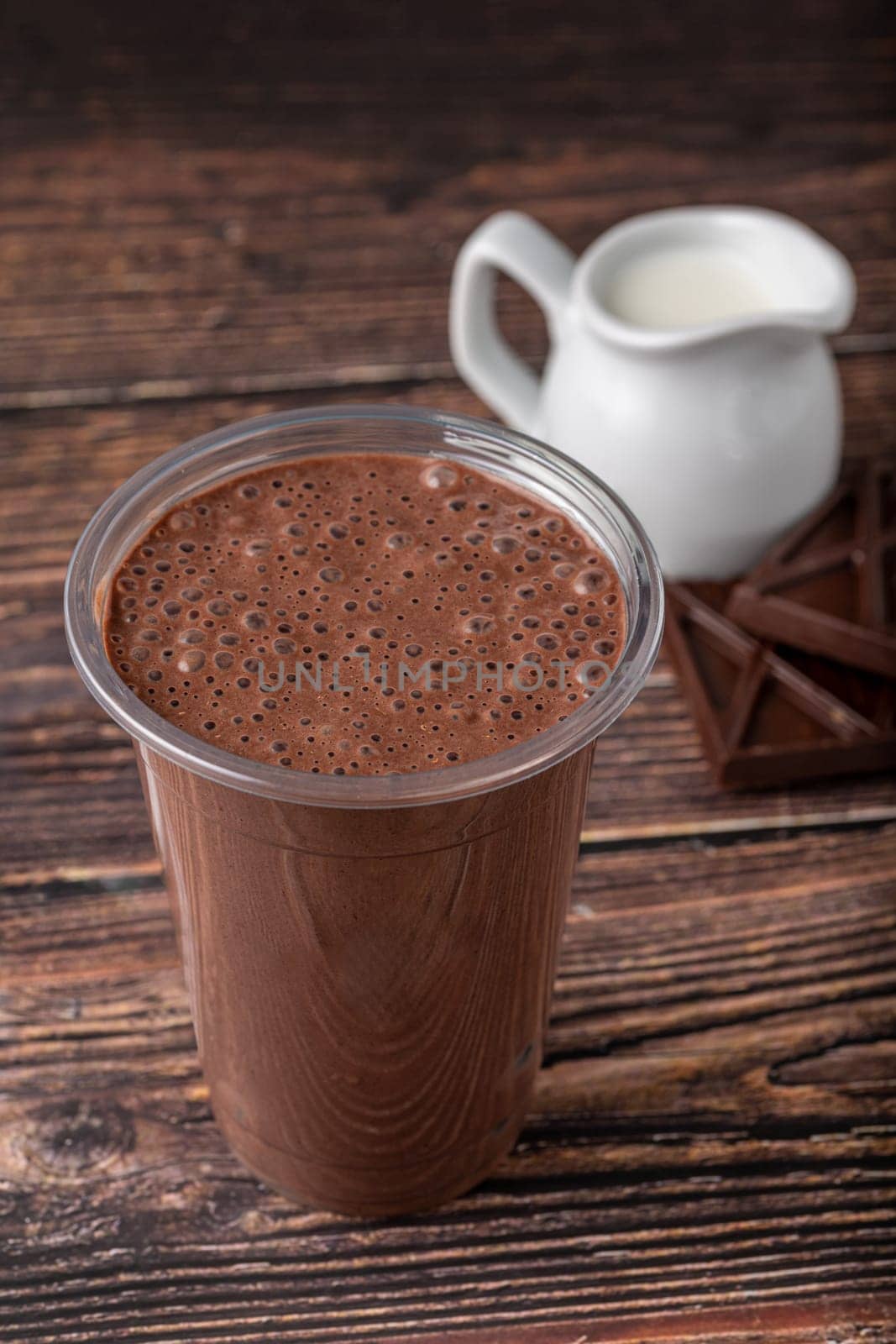 Chocolate milk in take away glass on wooden table by Sonat