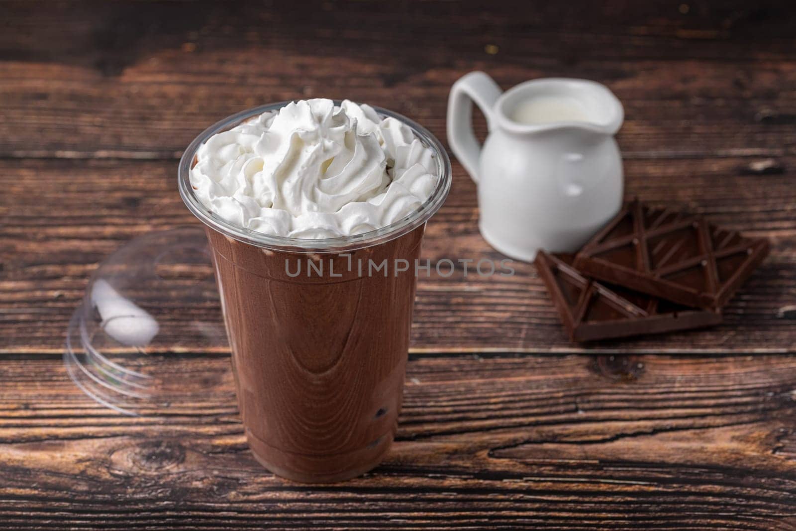 Chocolate milk in take away glass on wooden table by Sonat