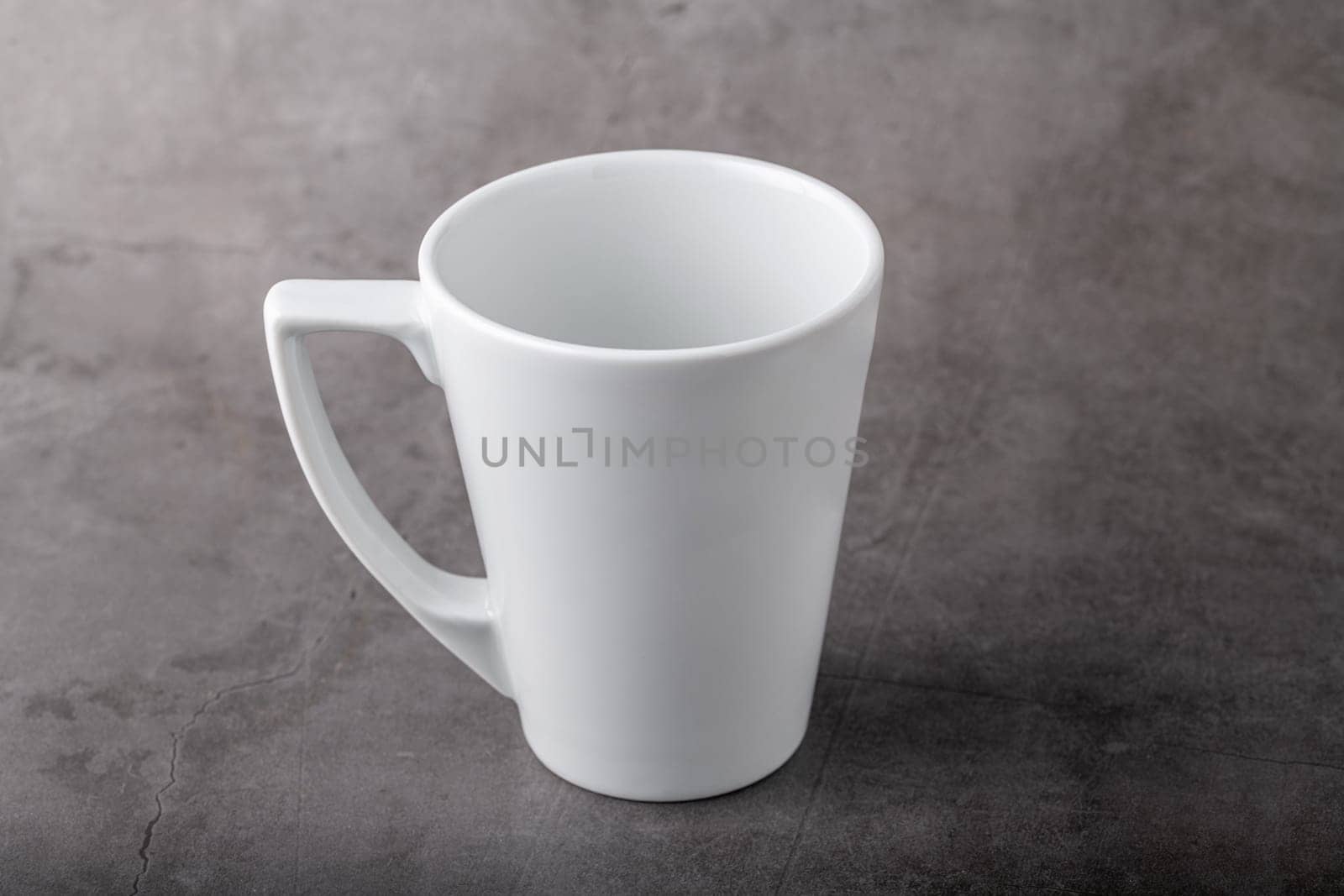 Empty white porcelain cup on gray stone background by Sonat