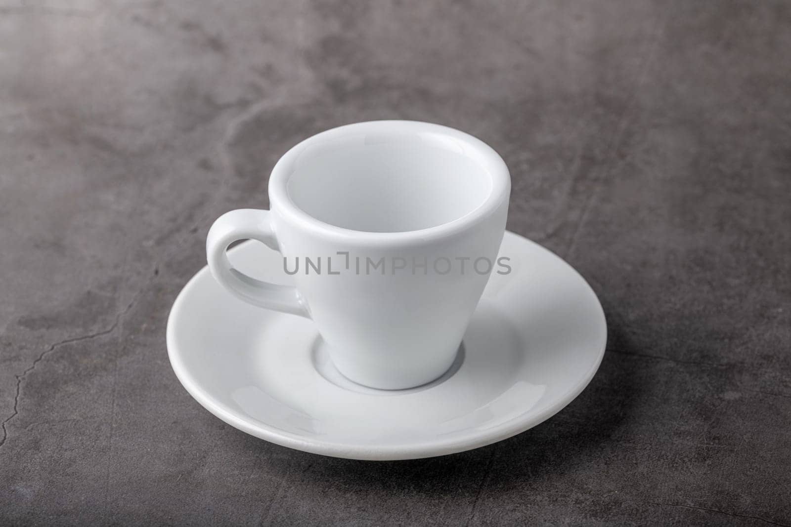 Empty white porcelain cup on gray stone background