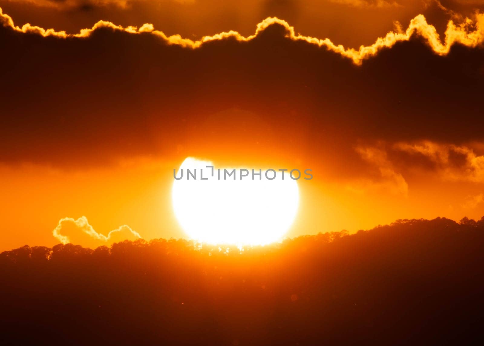 Beautiful nature sky with orange, yellow sunshine and fluffy clouds. Time lapse of a beautiful dramatic sky with a big sun at sunset or sunrise.