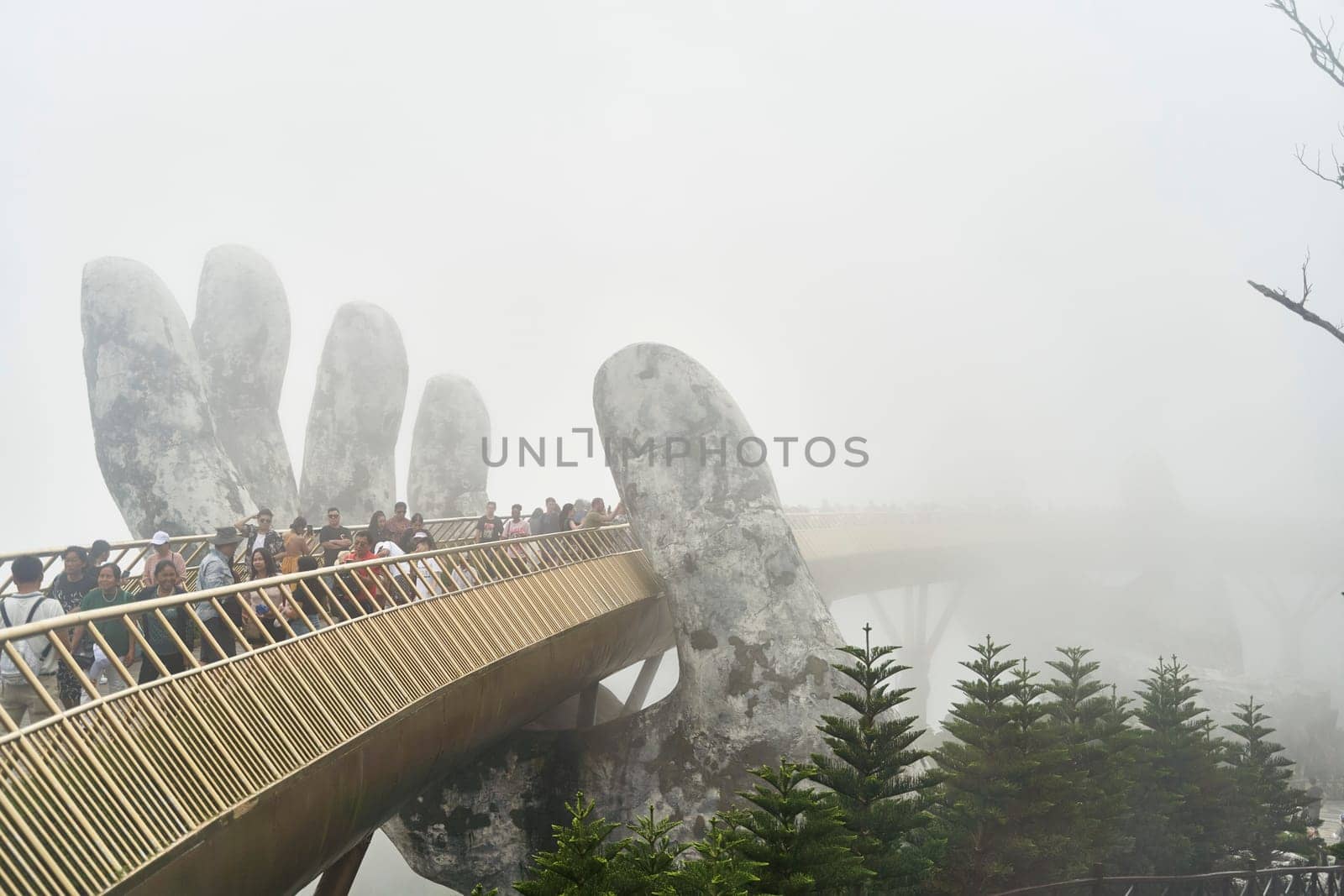 Danang, Vietnam - June 27, 2023: The Golden Bridge is lifted by two giant hands in the tourist resort on Ba Na Hill in Danang, Vietnam.