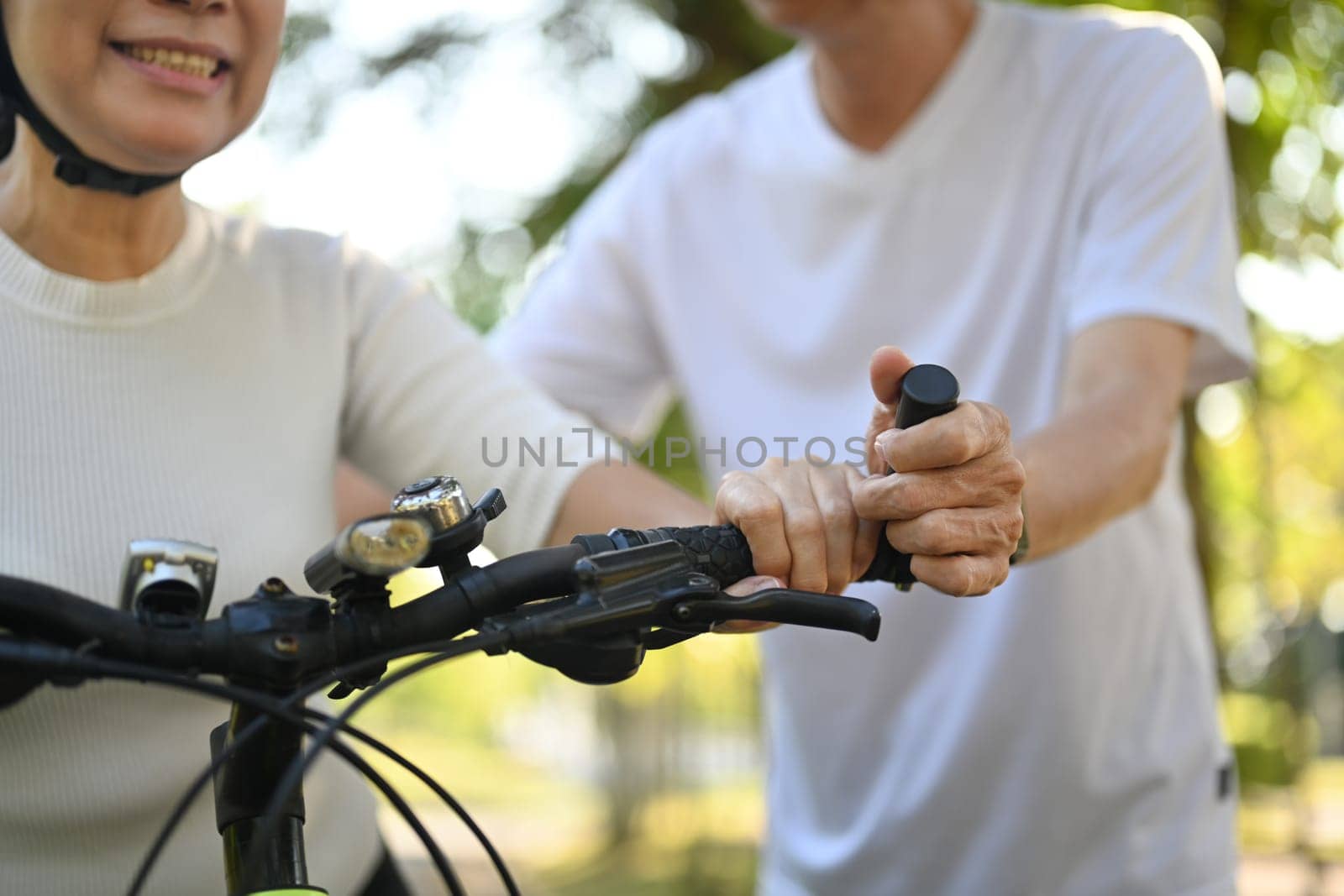 Active senior couple enjoying riding bikes together in nature. Healthy lifestyle concept