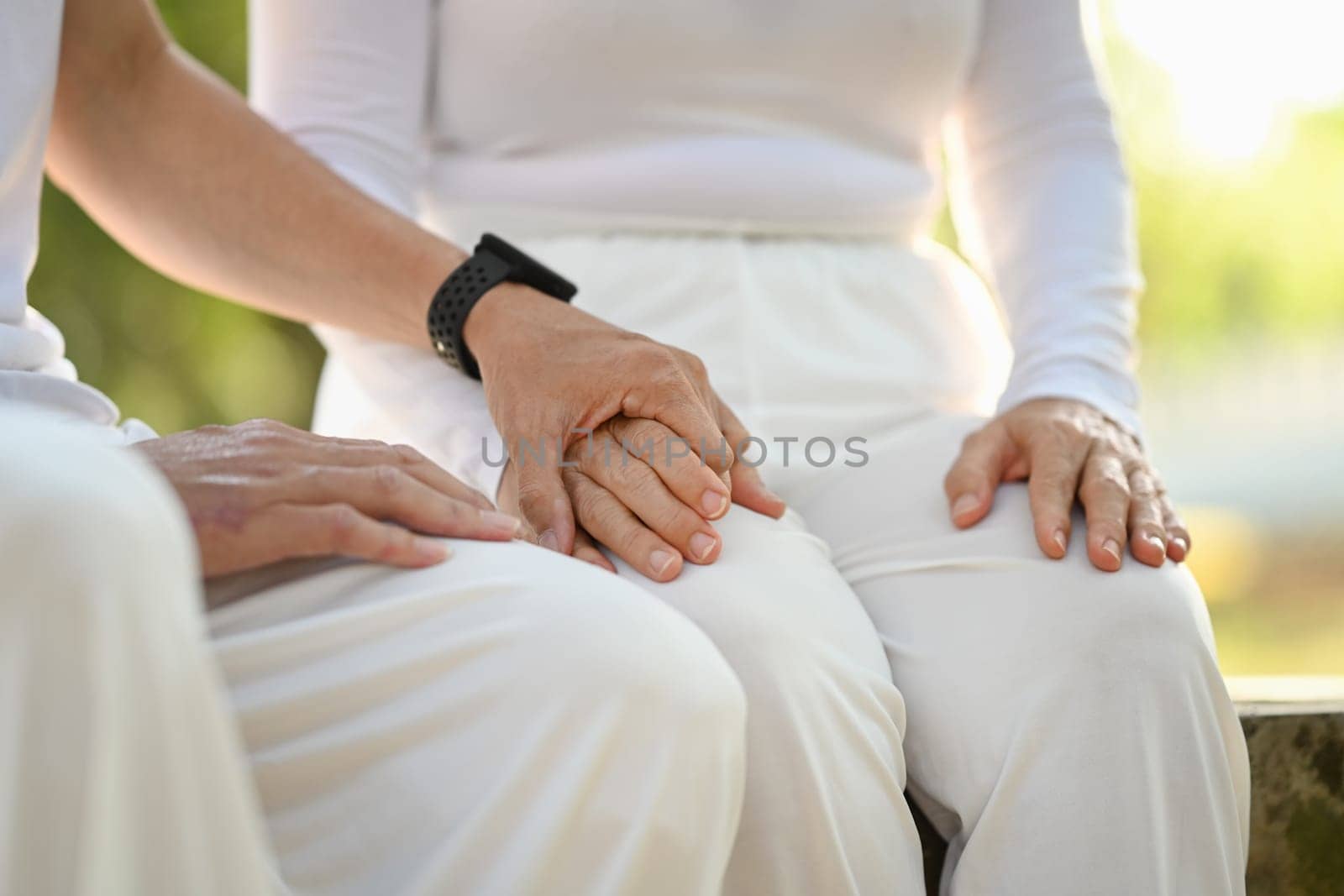 Closeup loving senior couple holding hands symbolizing supporting, empathy and understanding
