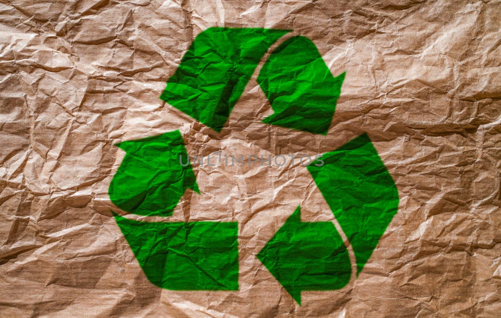 recycled paper with a lot of texture and brown tone with the Recycle logo printed on the paper. Recycling concept.