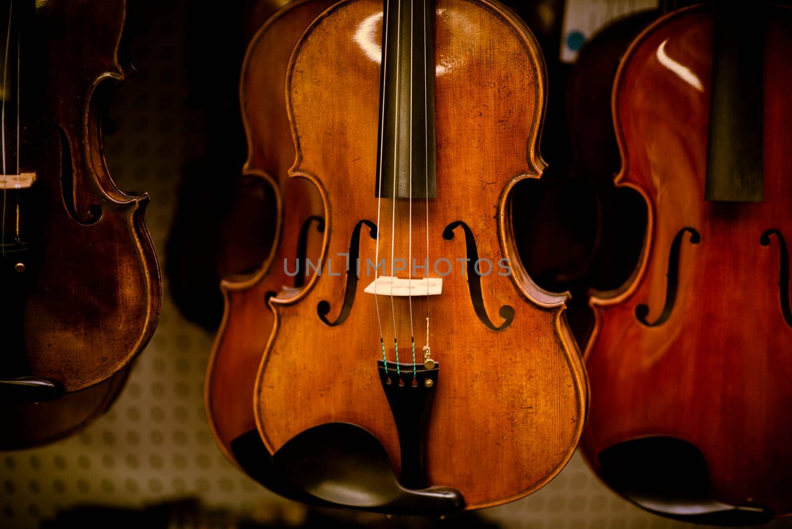 Violins are hanging in retail store to sell by iansaf