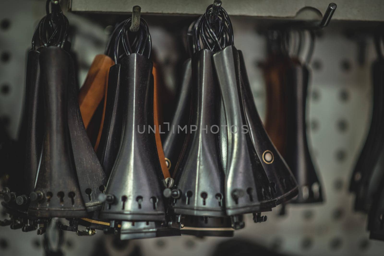 Violin Tailpieces hanging in a shop.part of acoustic instrument by iansaf