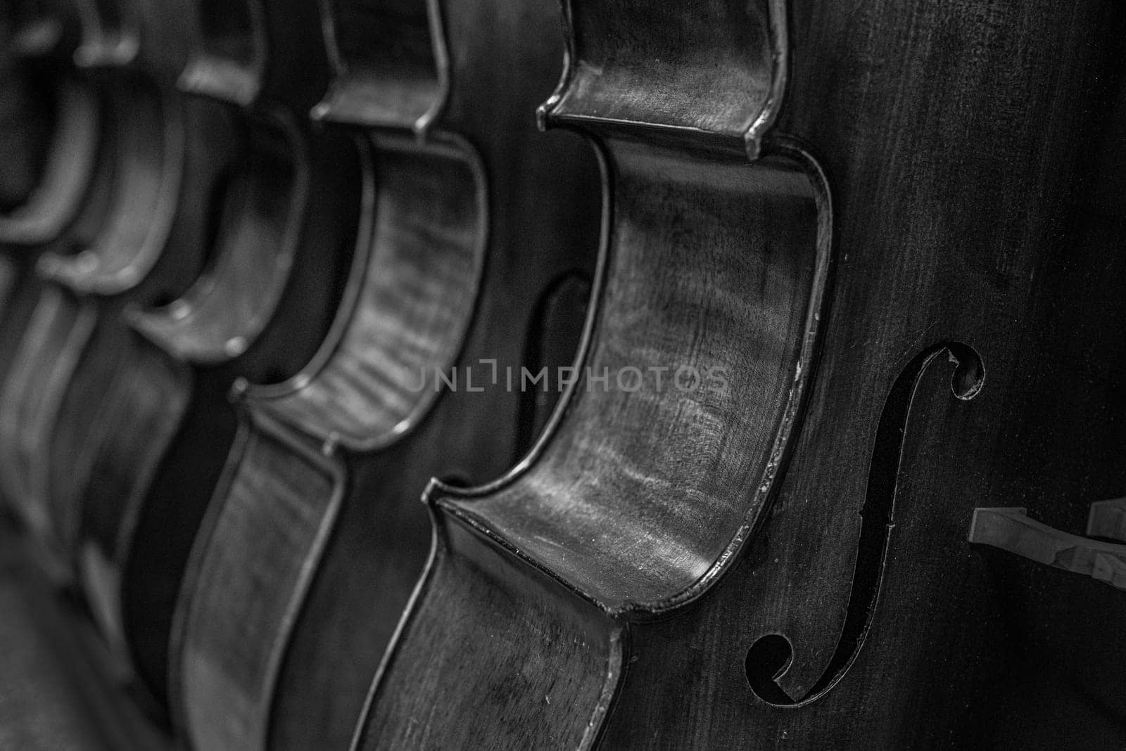 close up of a Row of multiple cellos standing on the floor