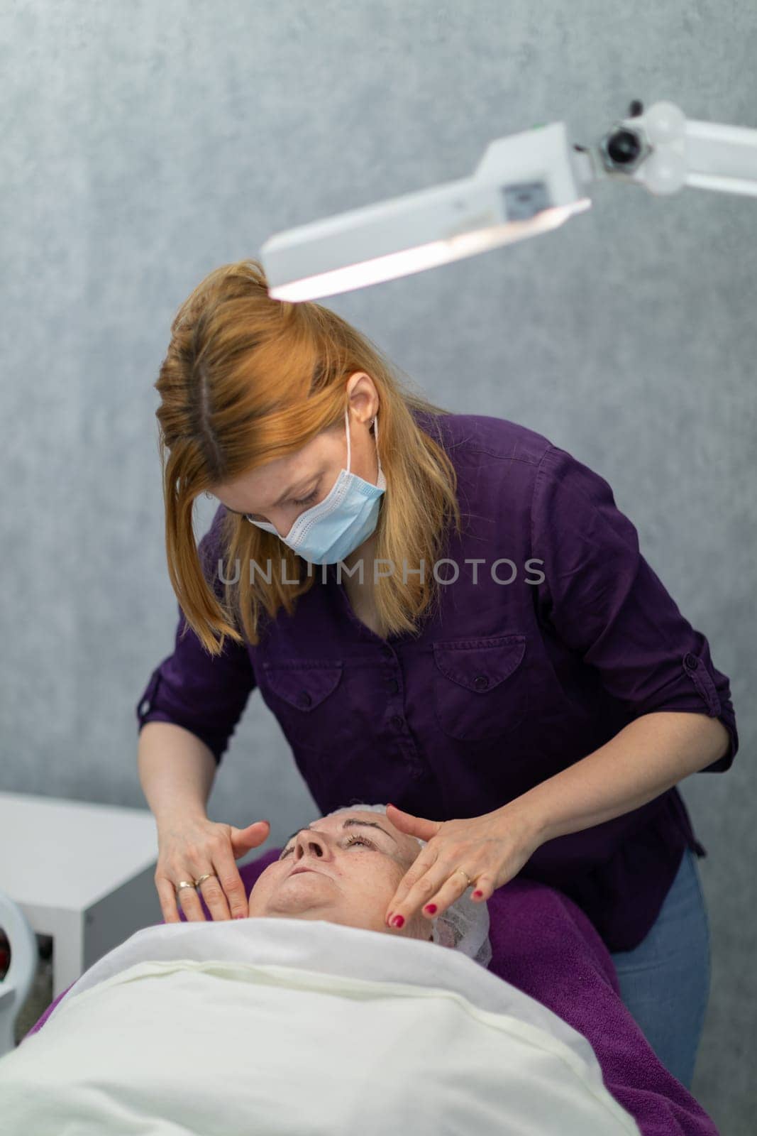 An experienced beautician performs a gentle facial massage for her client. by fotodrobik
