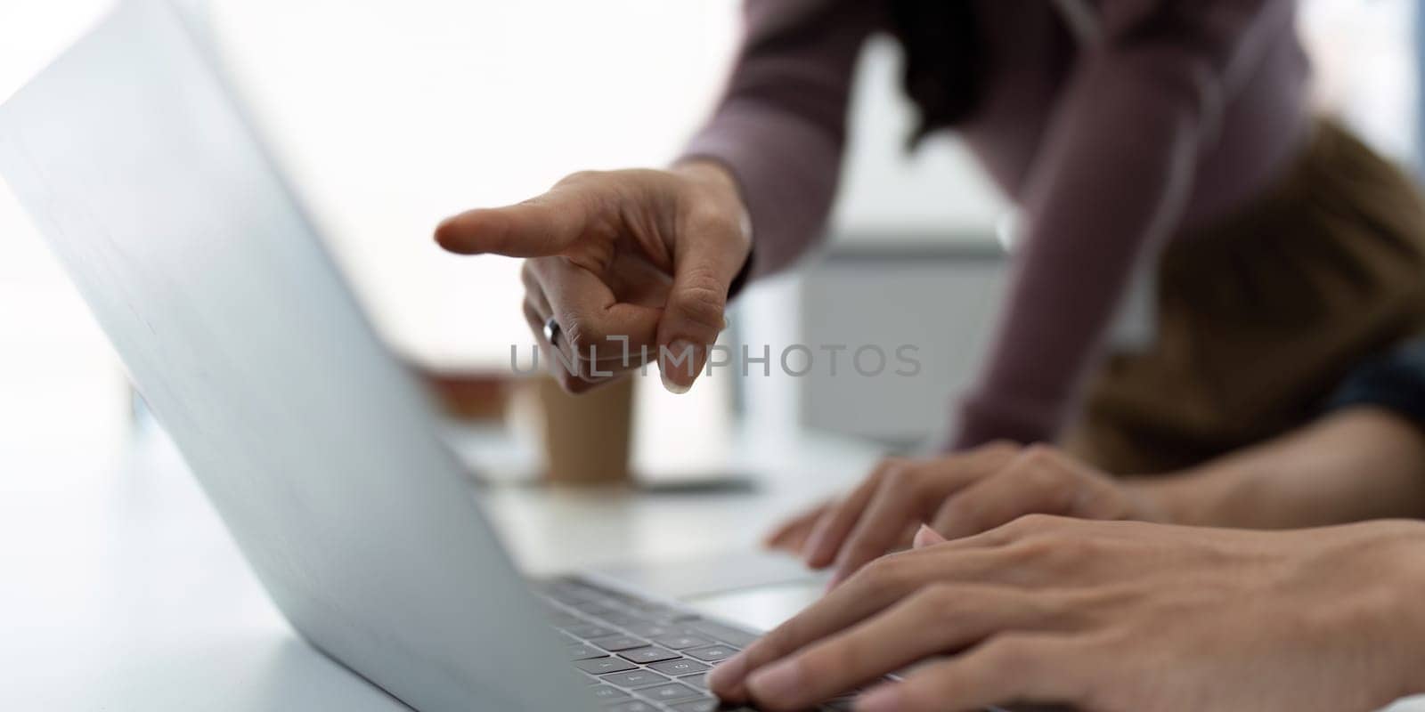 Business woman having a discussion with her colleague in meeting room. Two business people using a laptop in a meeting. Teamwork and collaboration between business professionals.