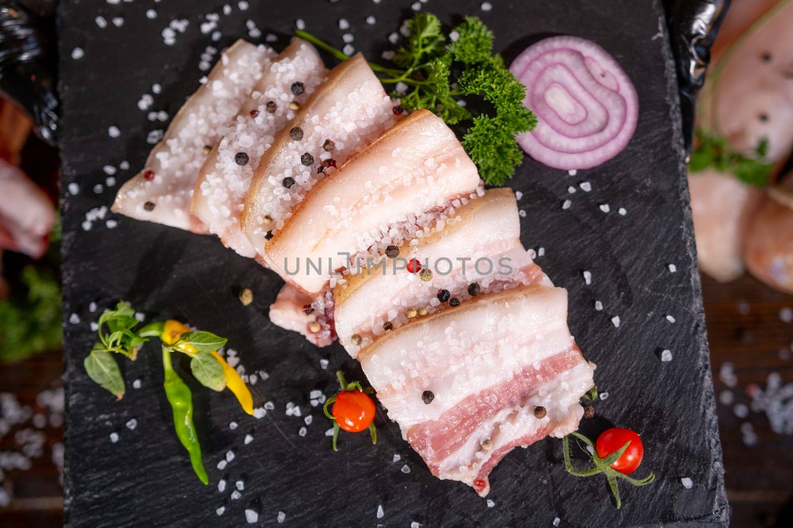 Smoked lard, bacon, half a piece, on a wooden dark craft background. Top view, close-up. High quality photo