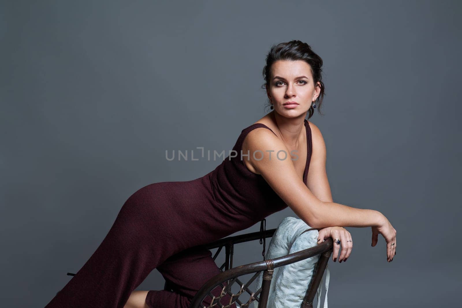 Fashionable sensual attractive young woman posing on dark gray studio background. Beauty, fashion, style concept