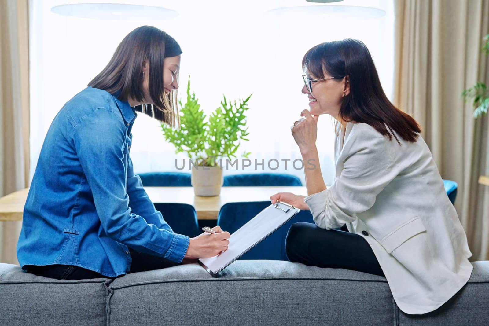 Mental therapy meeting exam of young woman with professional psychologist psychotherapist social worker advisor in office. Female patient chooses draws writes on clipboard. Psychology psychotherapy