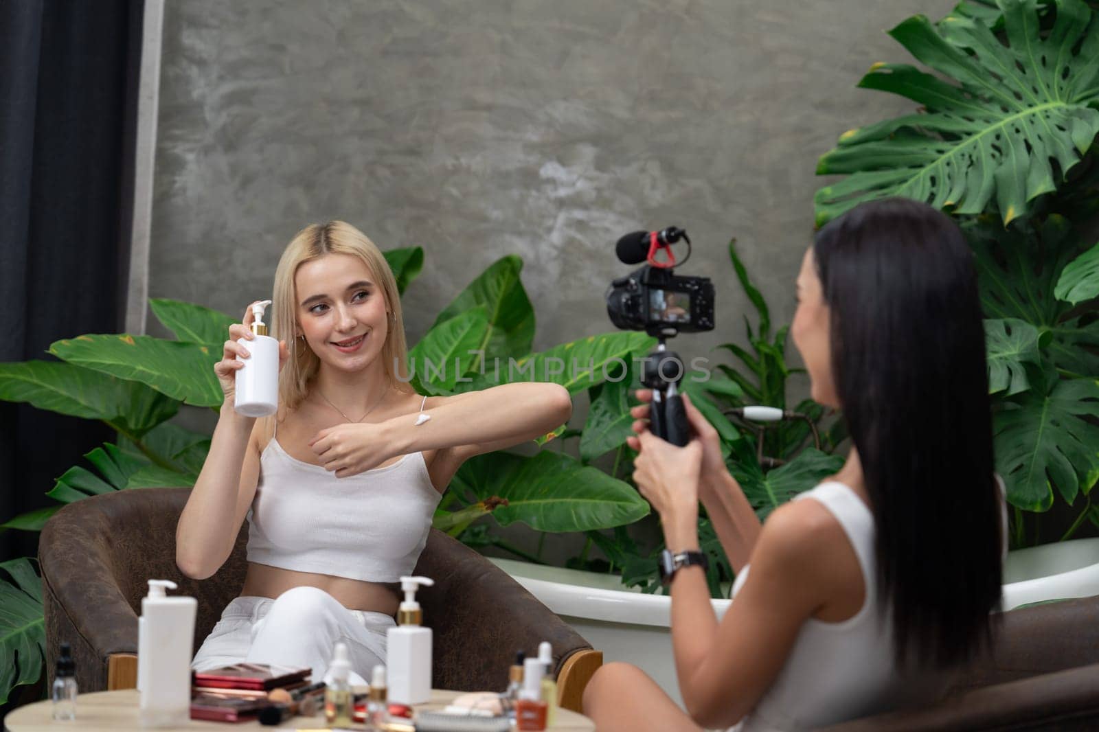 Two beautiful content creator making natural beauty and cosmetic tutorial on green plant garden video. Beauty blogger showing how to beauty care to social medial audience using selfie stick . Blithe