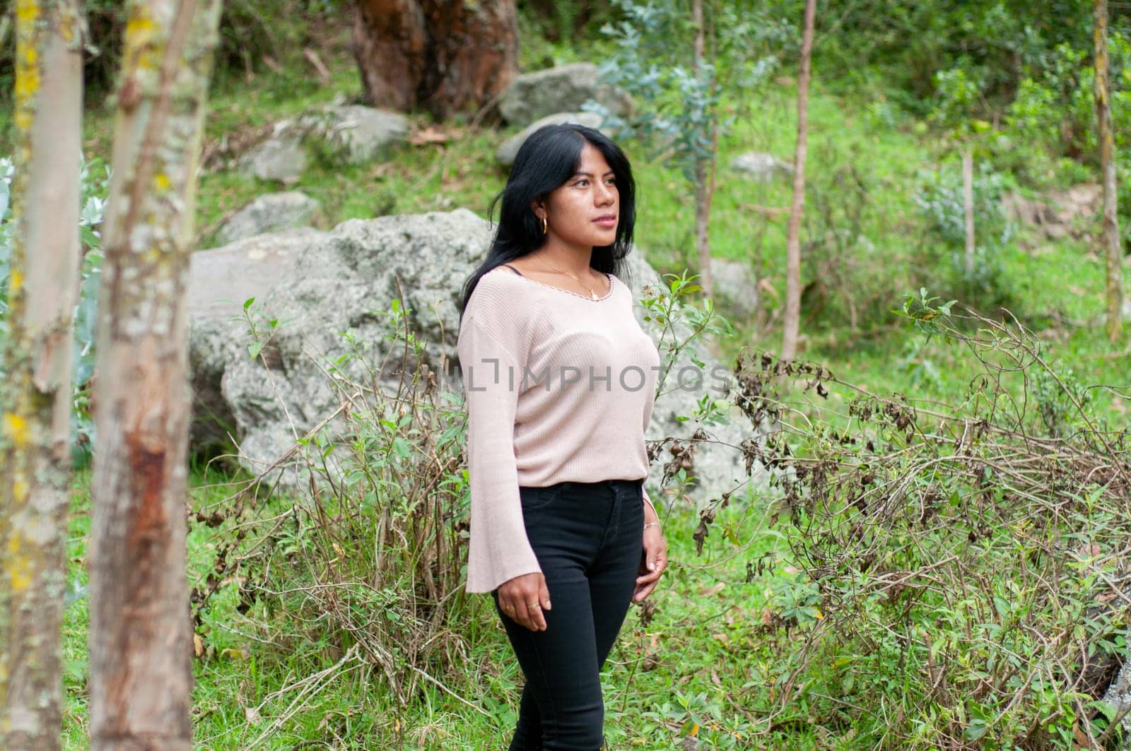 latin woman in black pants walking through a millenary quarry among rocks and trees. day of rural tourism by Raulmartin