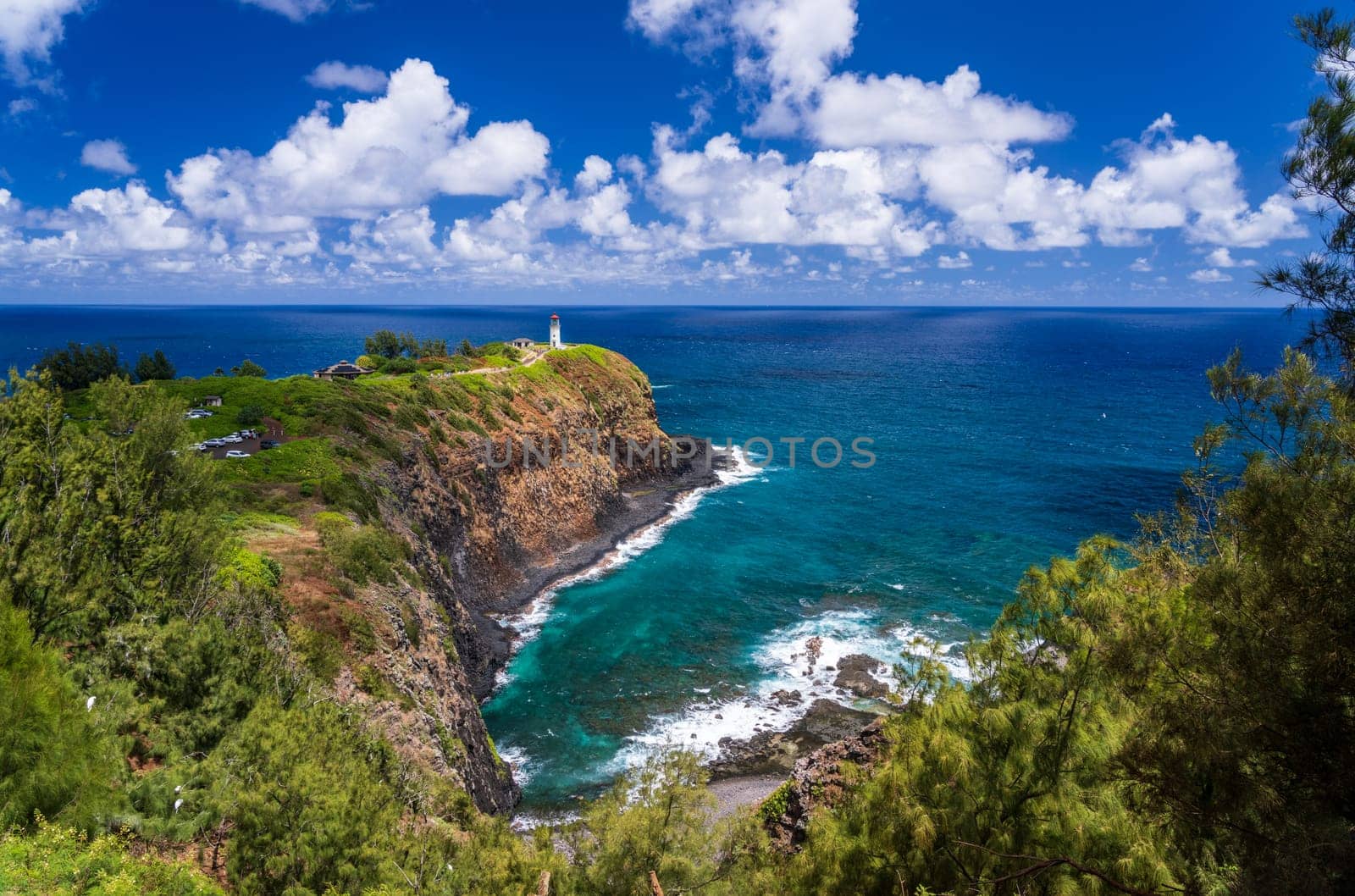 Kilauae lighthouse on headland against blue sky on Kauai by steheap