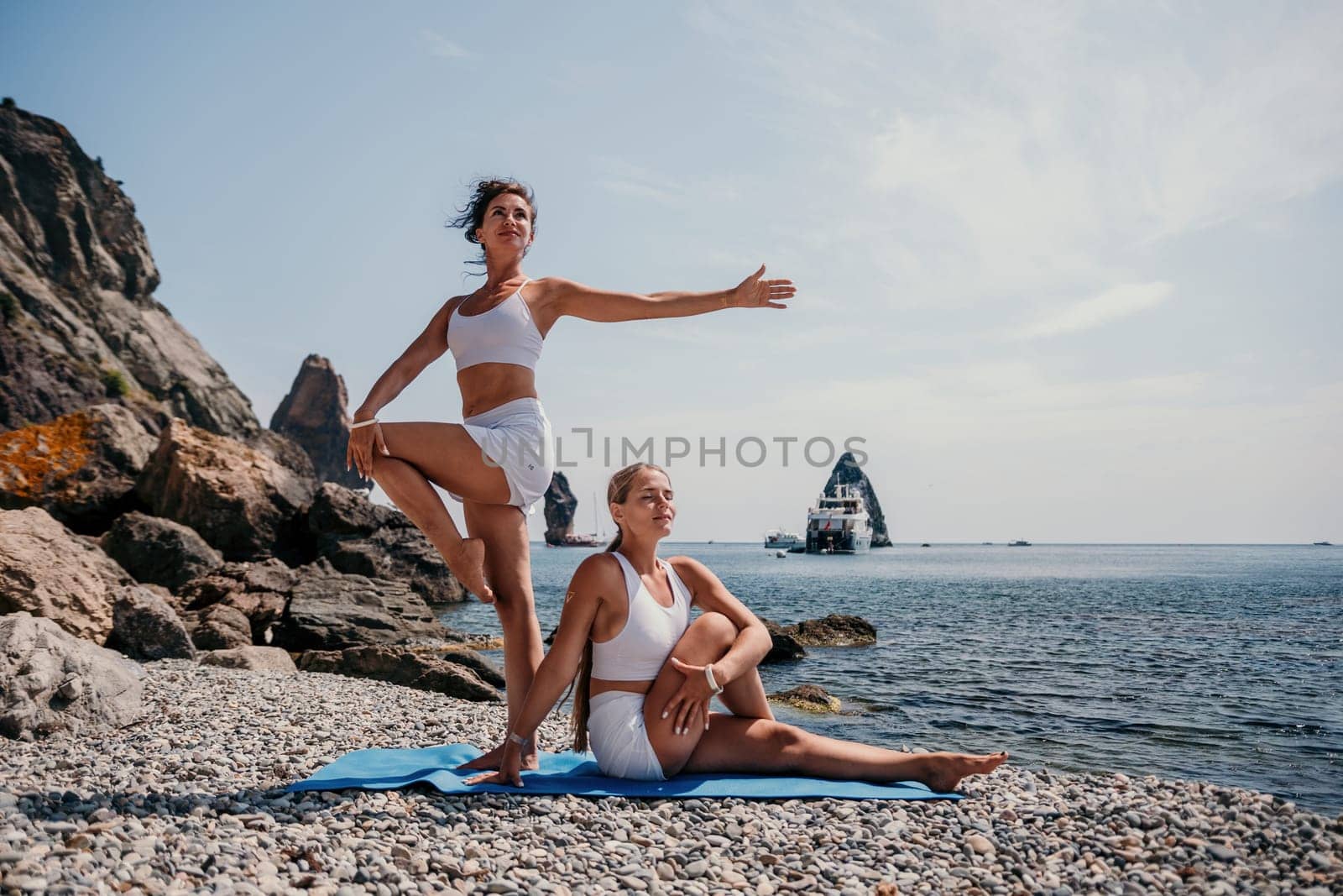 Woman sea yoga. Back view of free calm happy satisfied woman with long hair standing on top rock with yoga position against of sky by the sea. Healthy lifestyle outdoors in nature, fitness concept.