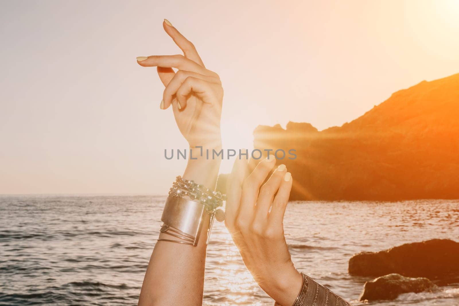 Young woman in swimsuit with long hair practicing stretching outdoors on yoga mat by the sea on a sunny day. Women's yoga fitness pilates routine. Healthy lifestyle, harmony and meditation concept.