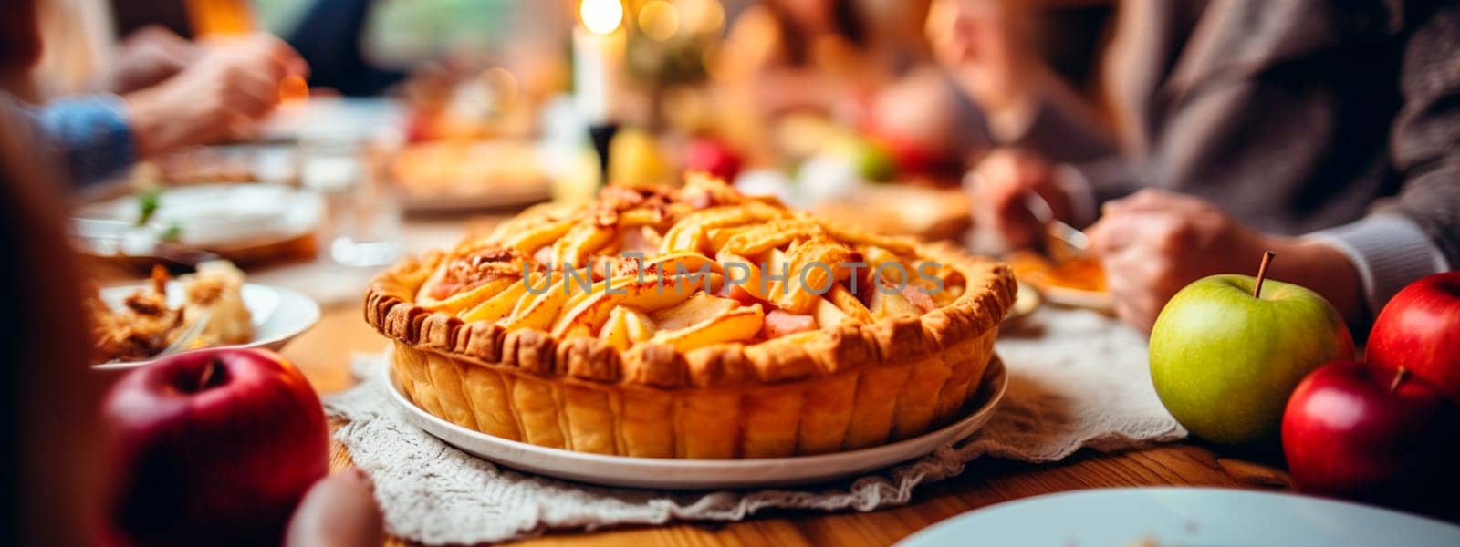 apple pie on the table against the backdrop of a family dinner. Selective focus. by yanadjana