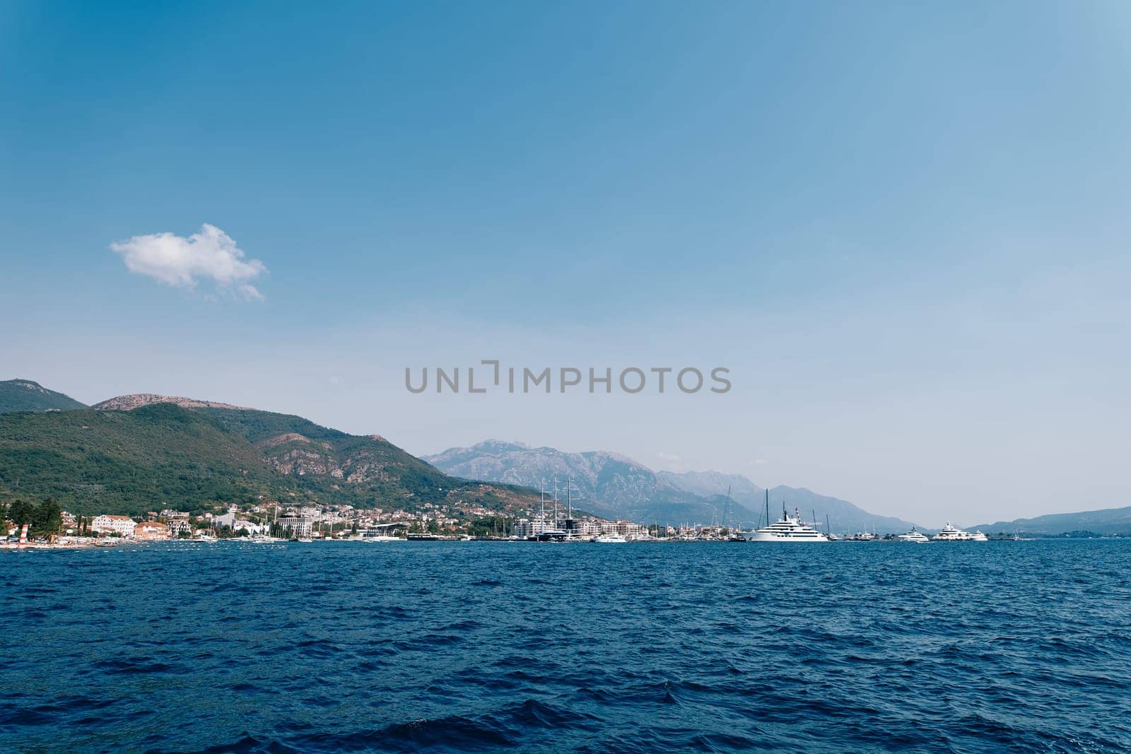 Yachts sail in the sea against the background of a mountainous resort coast. High quality photo