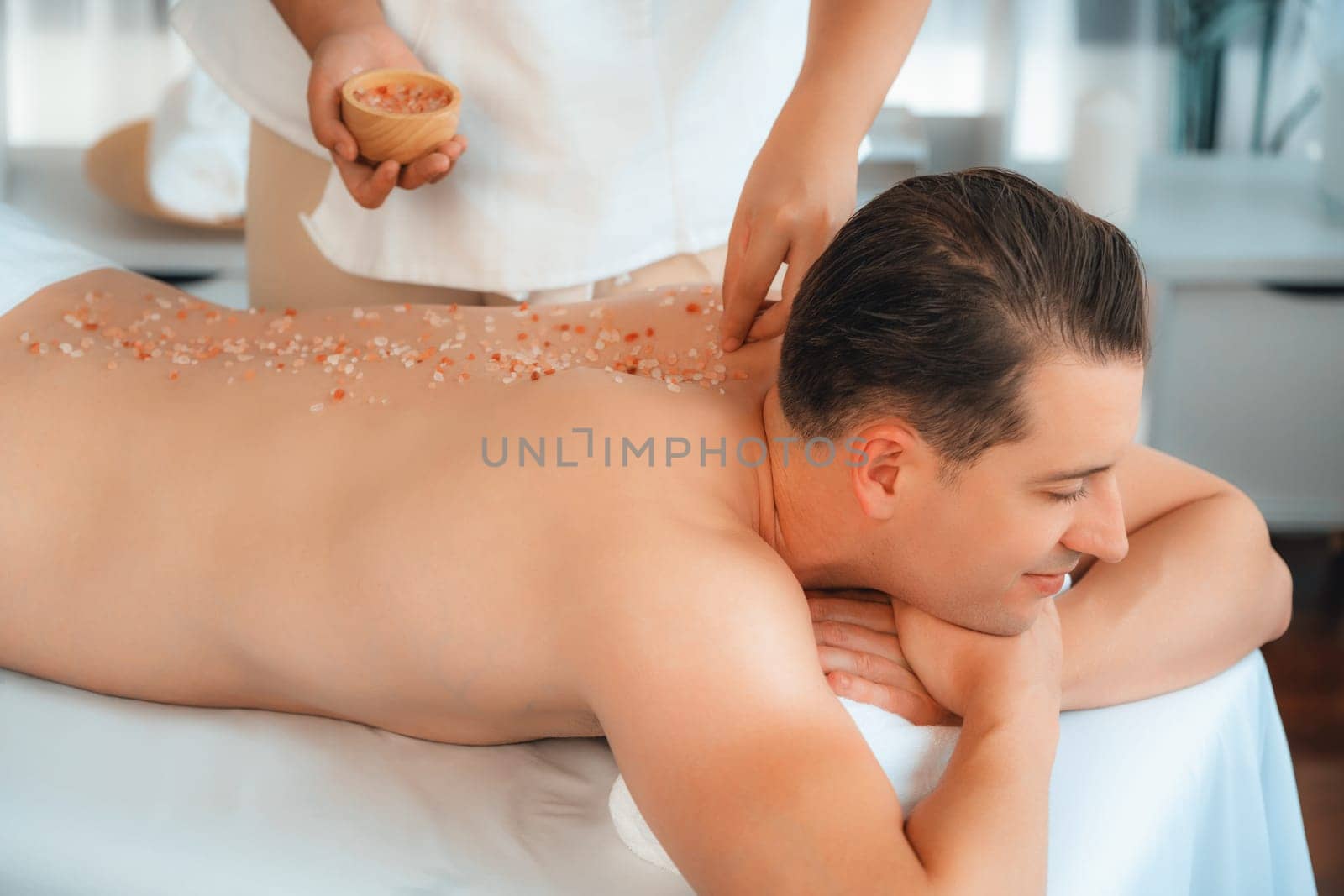 Blissful man customer having exfoliation treatment in luxury spa. Quiescent by biancoblue