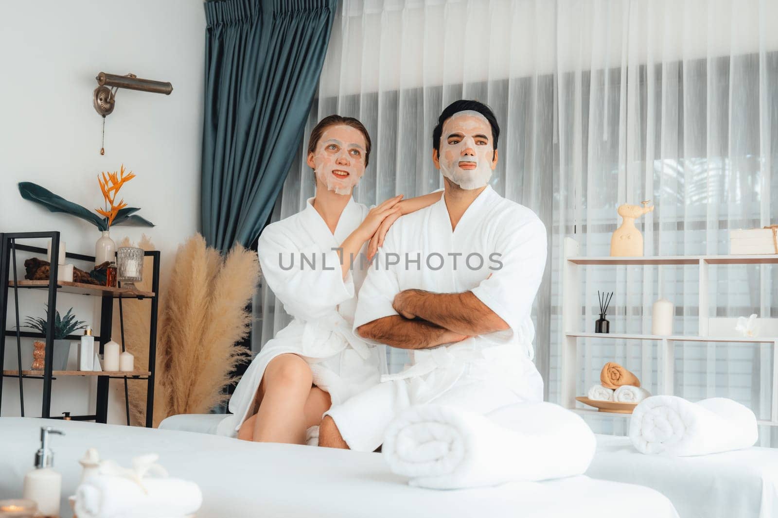 Serene modern daylight ambiance of spa salon, couple customer indulges in rejuvenating with facial skincare mask. Facial skin treatment and beauty cosmetology procedure for face. Quiescent