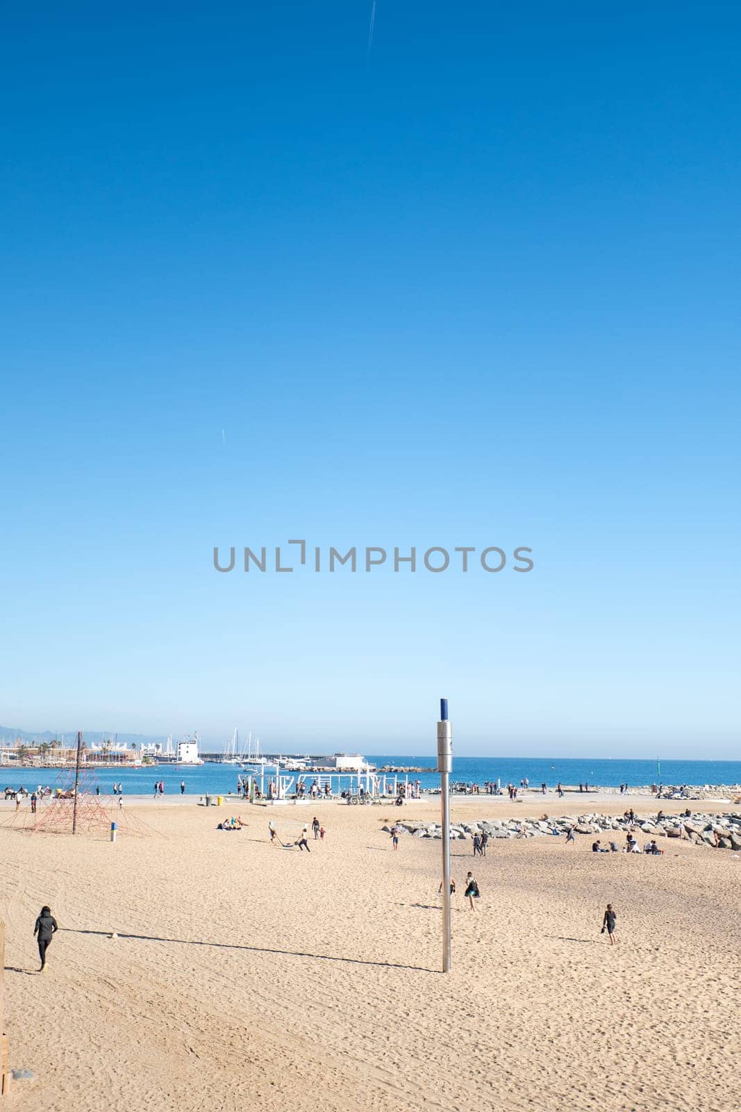 Barcelona, Spain: November 19, 2023: People in the Beach in Barcelona of La Barceloneta in the capital of Catalonia in Spain in 2023.