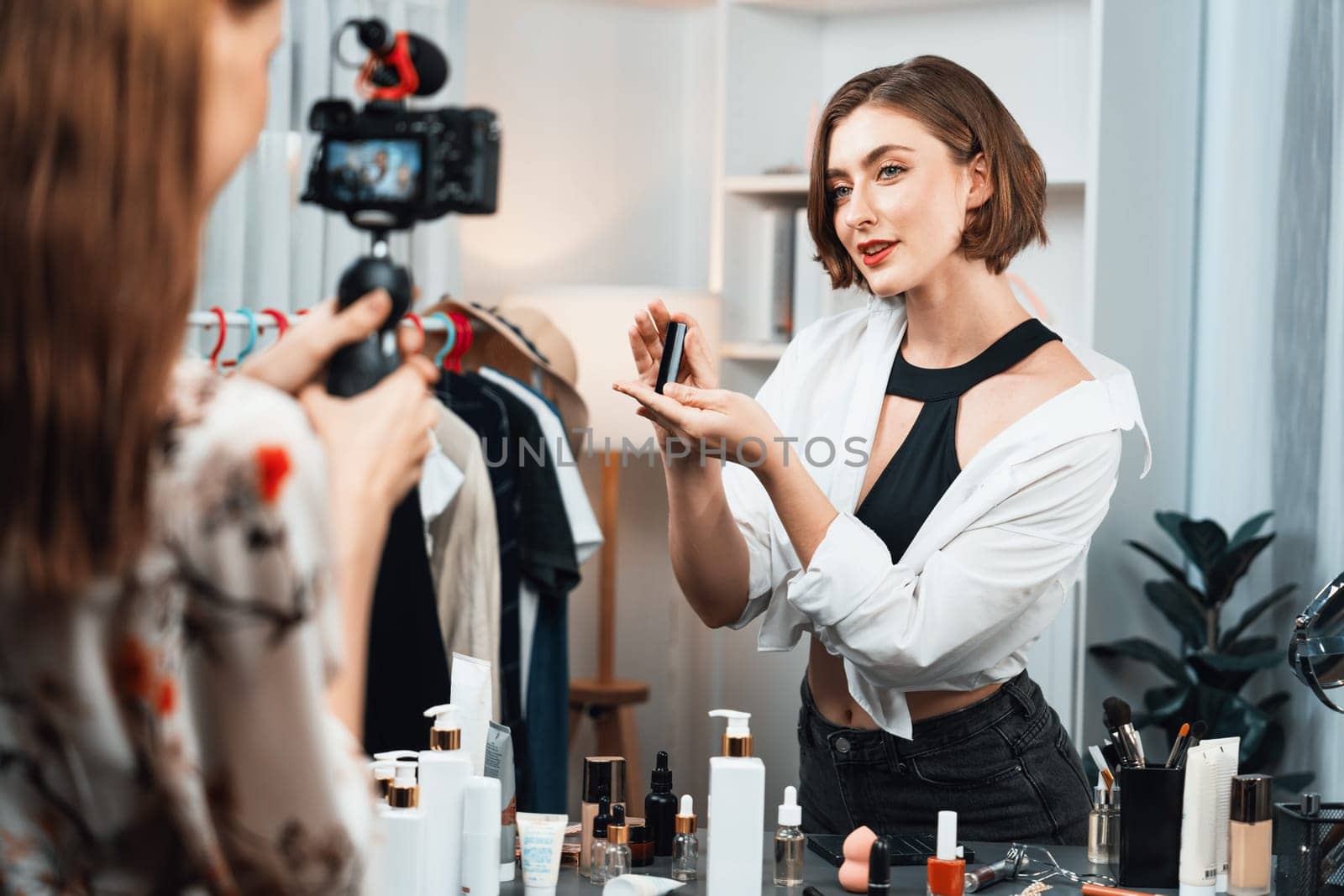 Woman influencer shoot live streaming vlog video review makeup utmost social media or blog. Happy young girl with cosmetics studio lighting for marketing recording session broadcasting online.