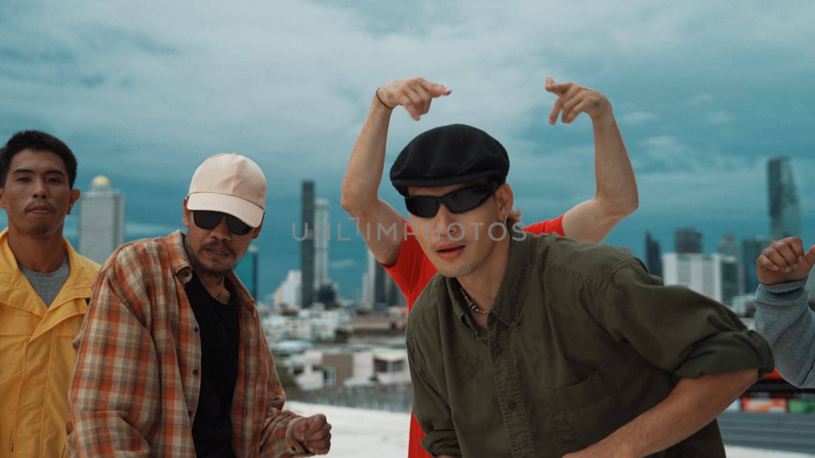 Skilled multicultural street dancing group pose at camera at roof top while moving to the rhyme and music. Young people or teenager moving to funky music, break dance. Outdoor sport 2024. Endeavor.