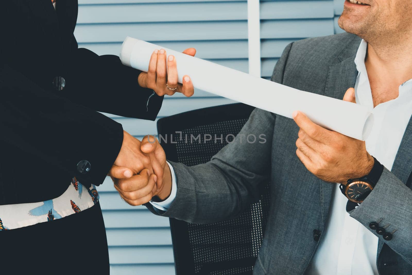 Businessman handshake businesswoman in office. uds by biancoblue
