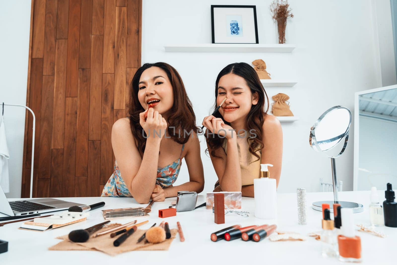 Asian Woman influencer shoot live streaming vlog video review makeup uttermost social media or blog. Happy young girl with cosmetics studio lighting for marketing recording session broadcasting online