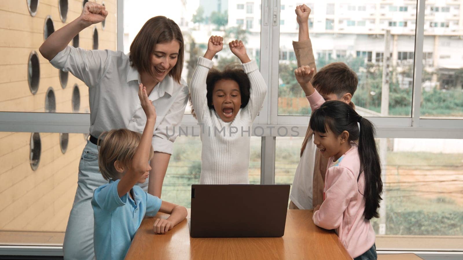 Group of diverse student and teacher celebrate successful project. Happy caucasian instructor looking at engineering code and cheering and encourage learner to improve skill at STEM class. Erudition.