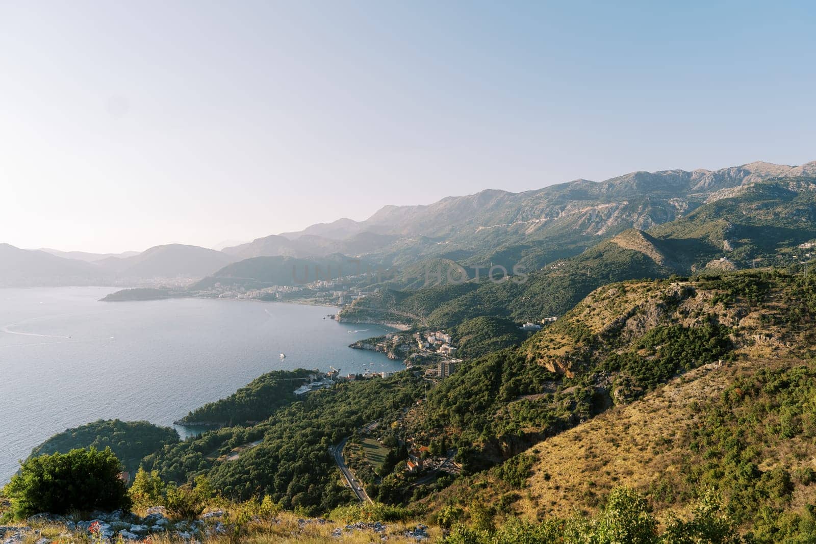 Blue bay at the foot of a mountain range against a clear horizon. High quality photo