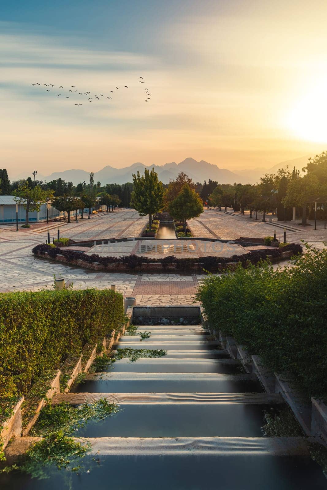 Sunset view of the walking path and ornamental pools in front of Antalya Glass Pyramid by Sonat