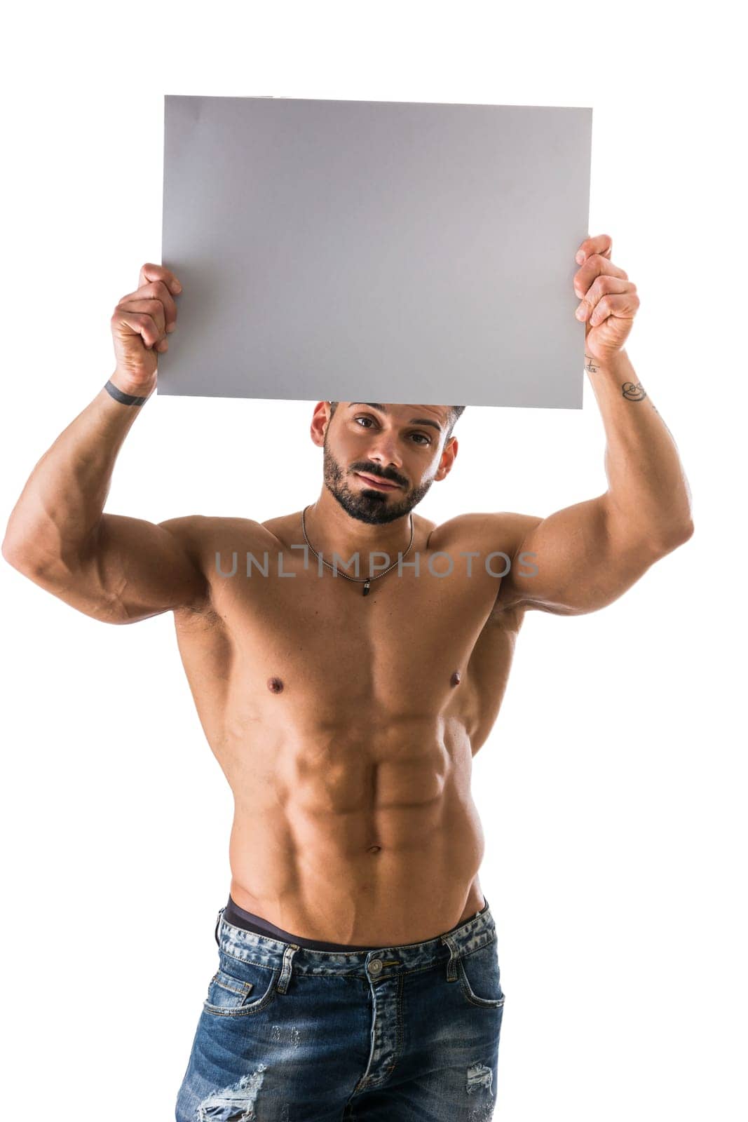 Naked young male bodybuilder holding blank white sign, isolated on white background, large copyspace