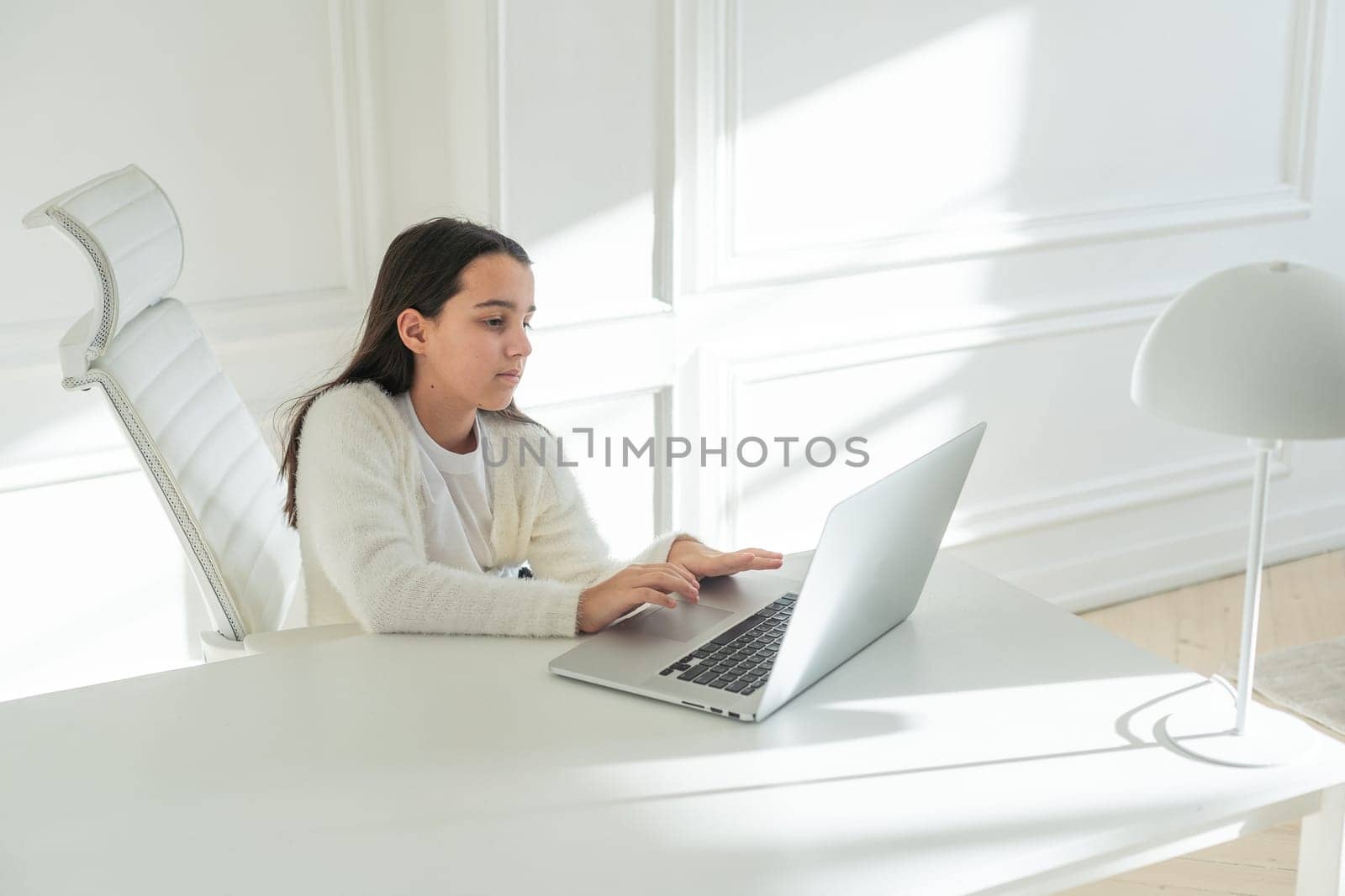 Online Fun. Smiling Middle Eastern Preteen Girl Using Laptop Computer, Relaxing Playing Games And Enjoying Web Entertainment At Home. Digital Weekend Leisure Concept. High quality photo