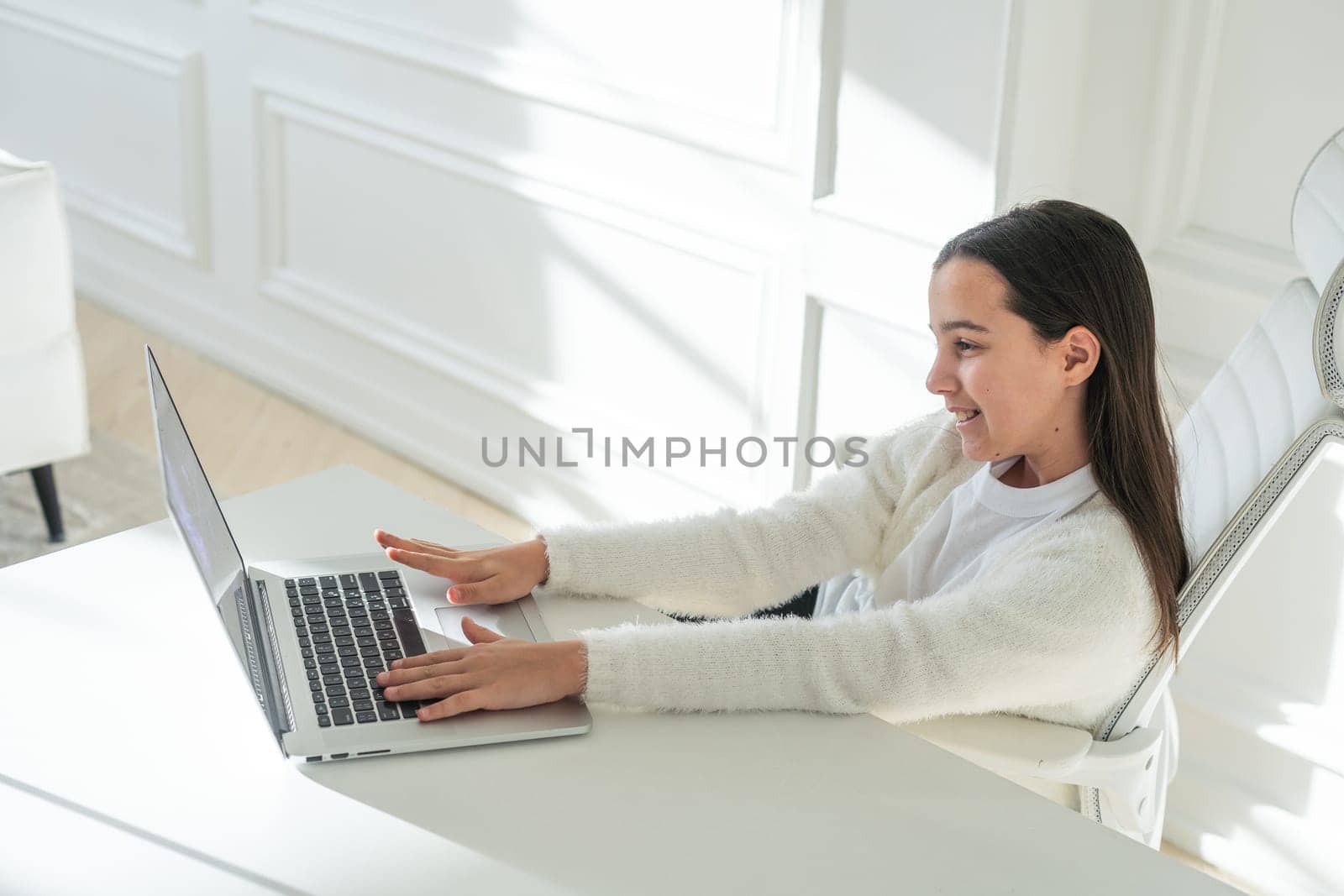 Online Fun. Smiling Middle Eastern Preteen Girl Using Laptop Computer, Relaxing Playing Games And Enjoying Web Entertainment At Home. Digital Weekend Leisure Concept. High quality photo