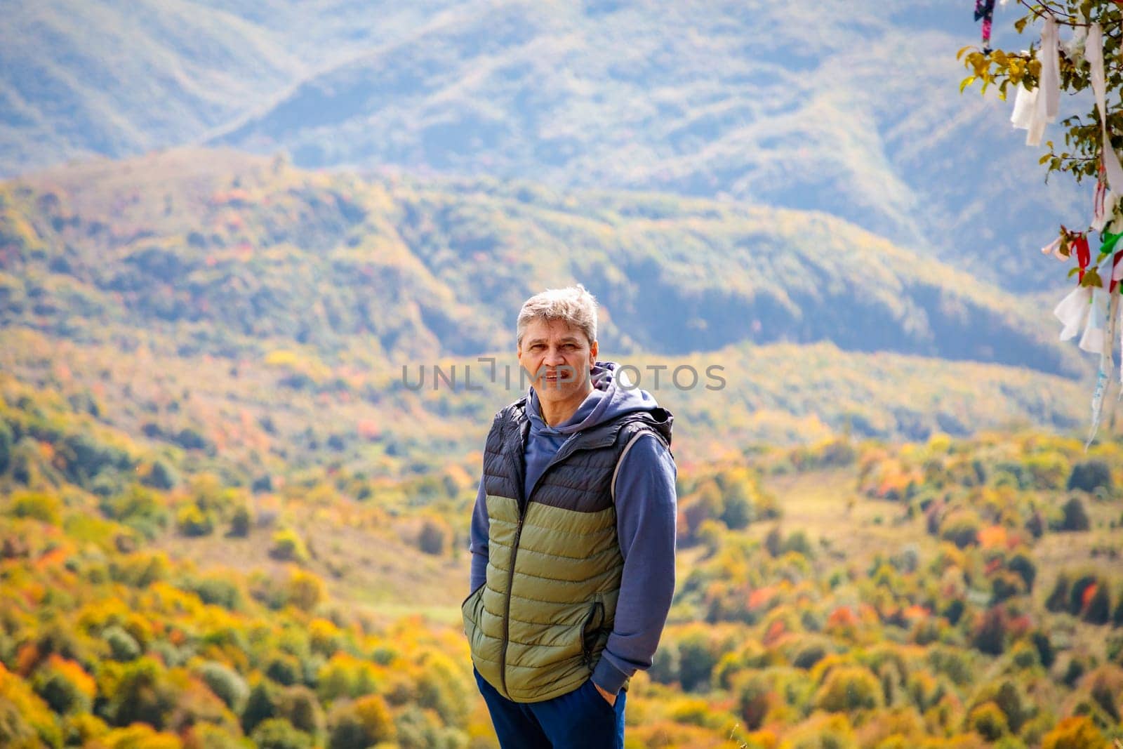 Man enjoying the view of autumn mountains, feeling the tranquility and majesty of nature