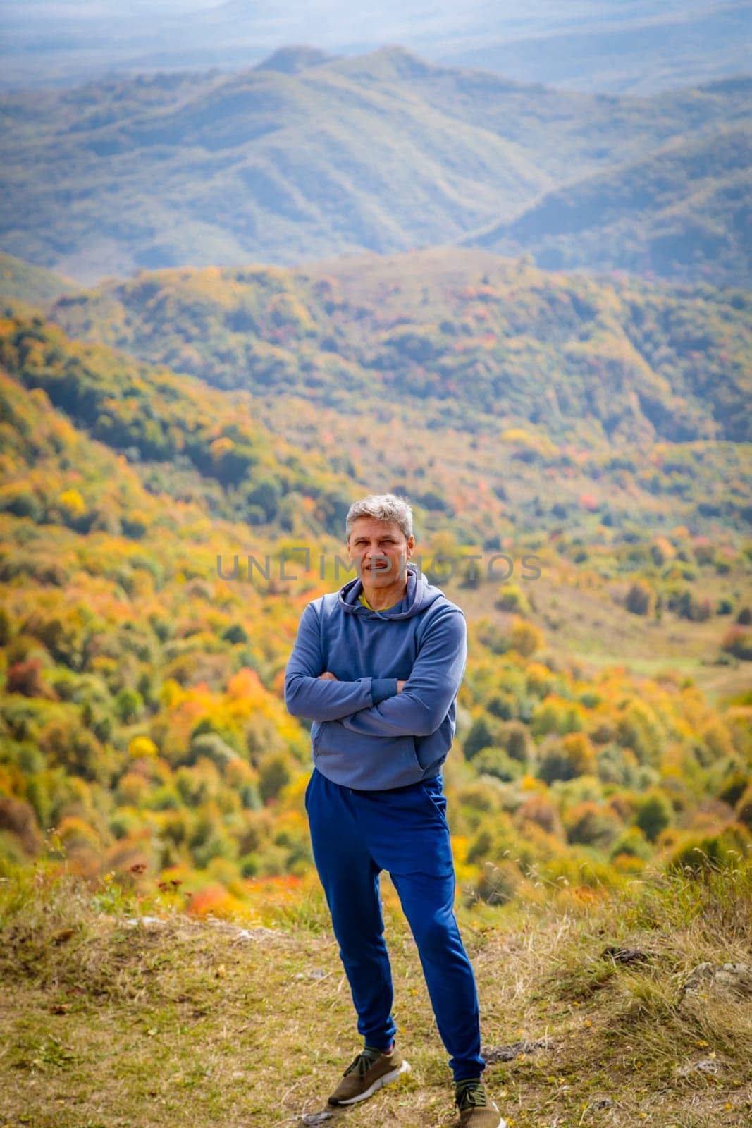 Man enjoying the view of autumn mountains, feeling the tranquility and majesty of nature