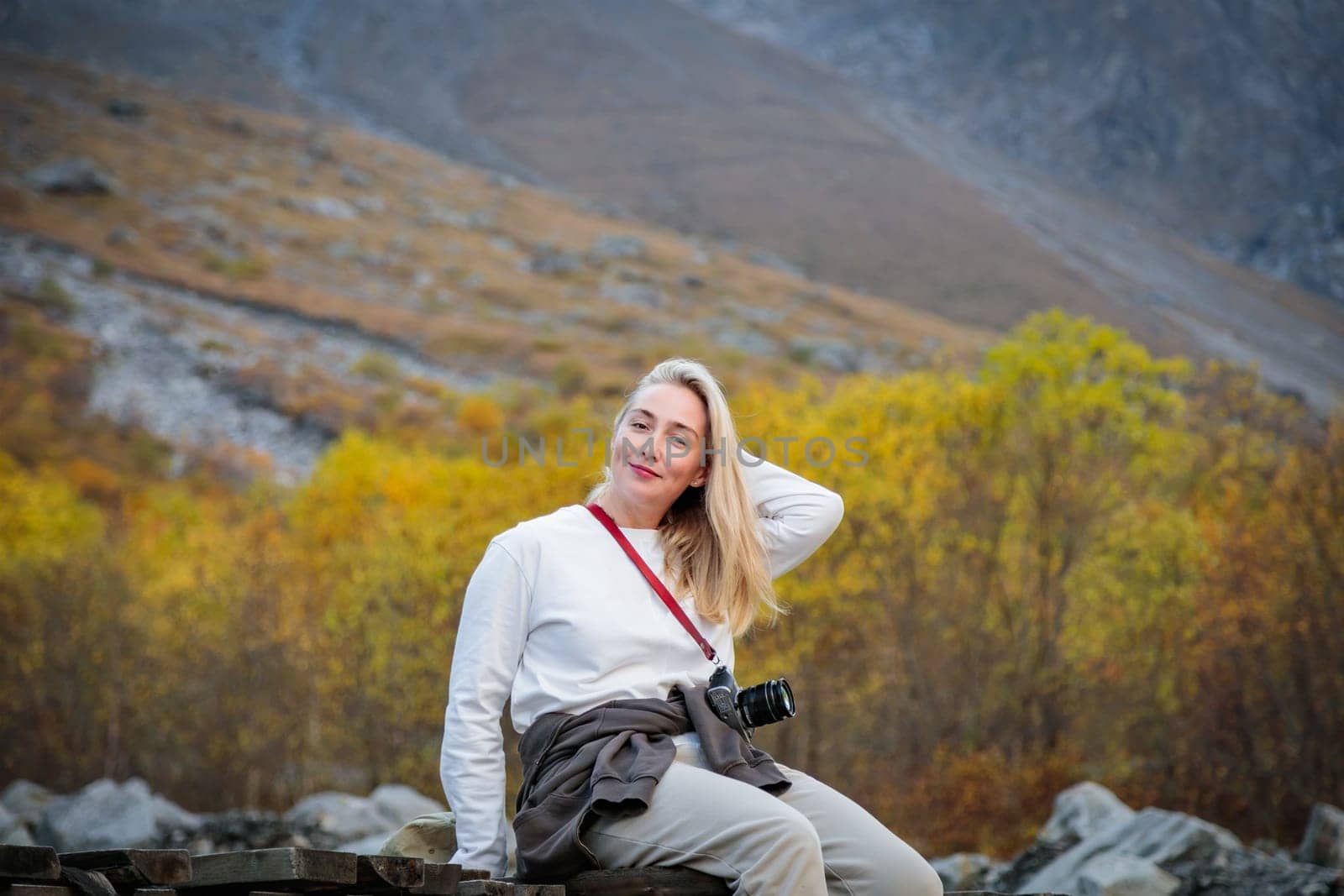 Force of Nature: A girl contemplates the majesty of a waterfall while sitting on a bridge in a mountain