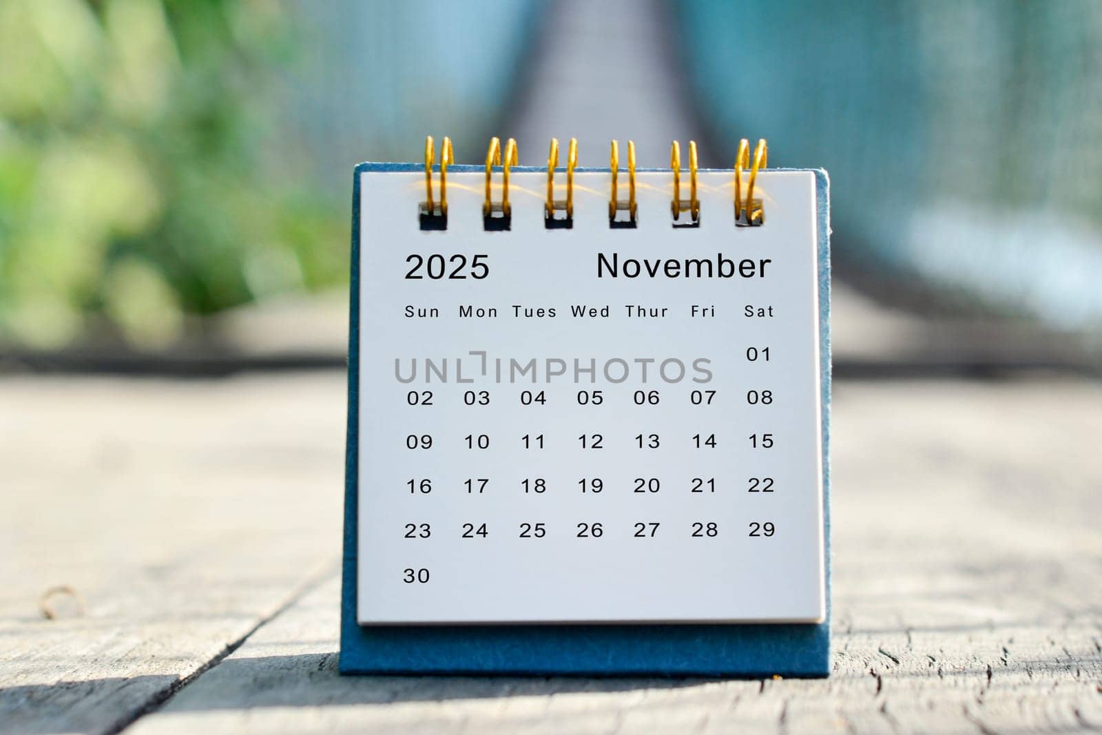 November 2025 white calendar with green blurred background. 2024 new year concept.