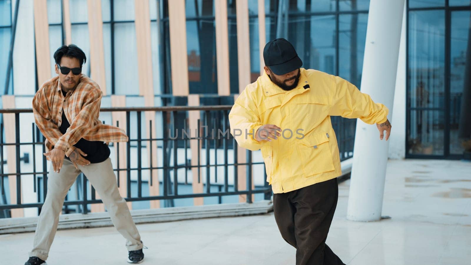 Hipster perform break dancing while partner dancing together at corridor, modern mall. Hip-hop music dancer practice footstep and move to music. Outdoor sport 2024. Active, energetic dance. Endeavor.