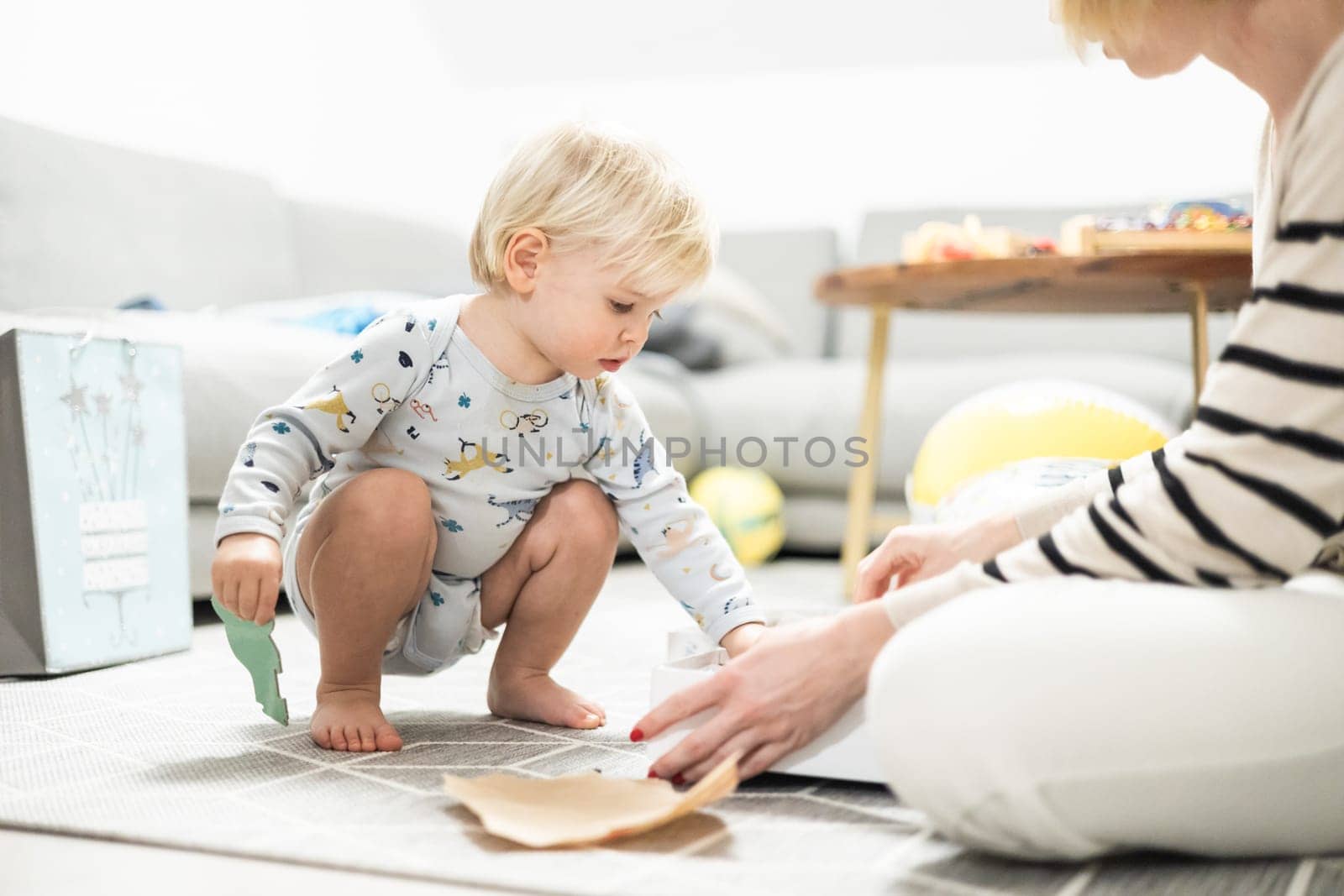 Parents playing games with child. Little toddler doing puzzle. Infant baby boy learns to solve problems and develops cognitive skills. Child development concept.