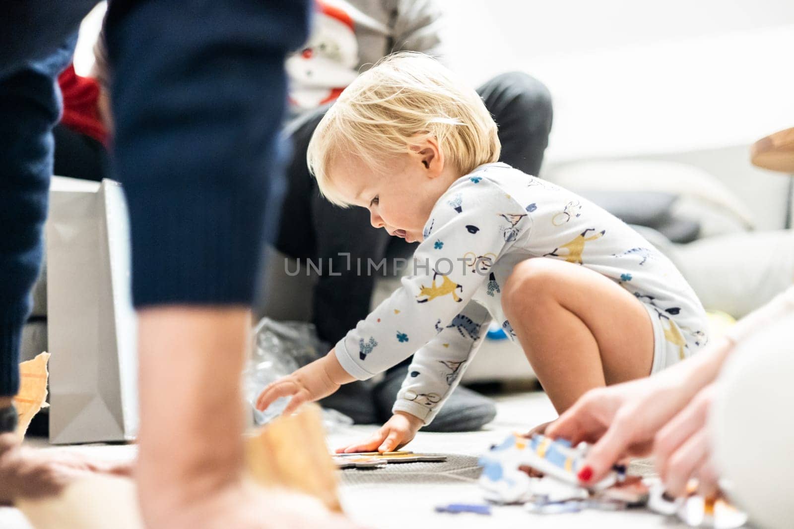 Parents playing games with child. Little toddler doing puzzle. Infant baby boy learns to solve problems and develops cognitive skills. Child development concept.