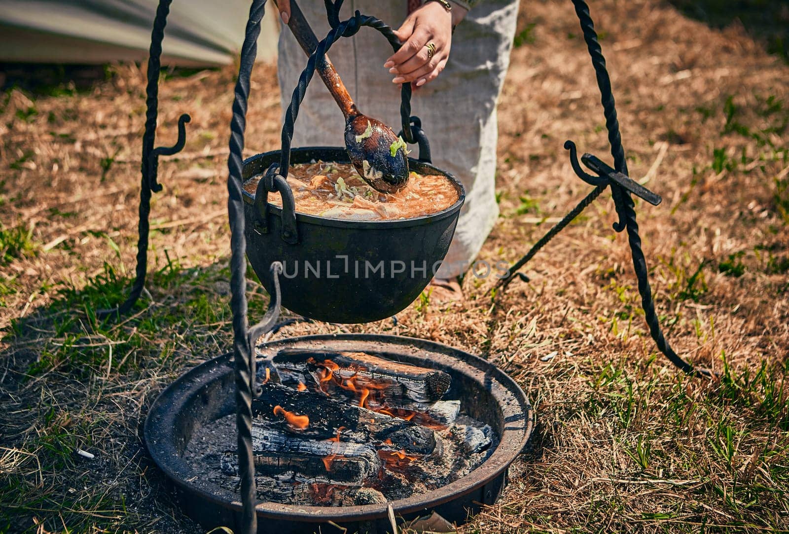 Camping. Soup in a pot over a fire. Stylization under the Middle Ages, vintage.