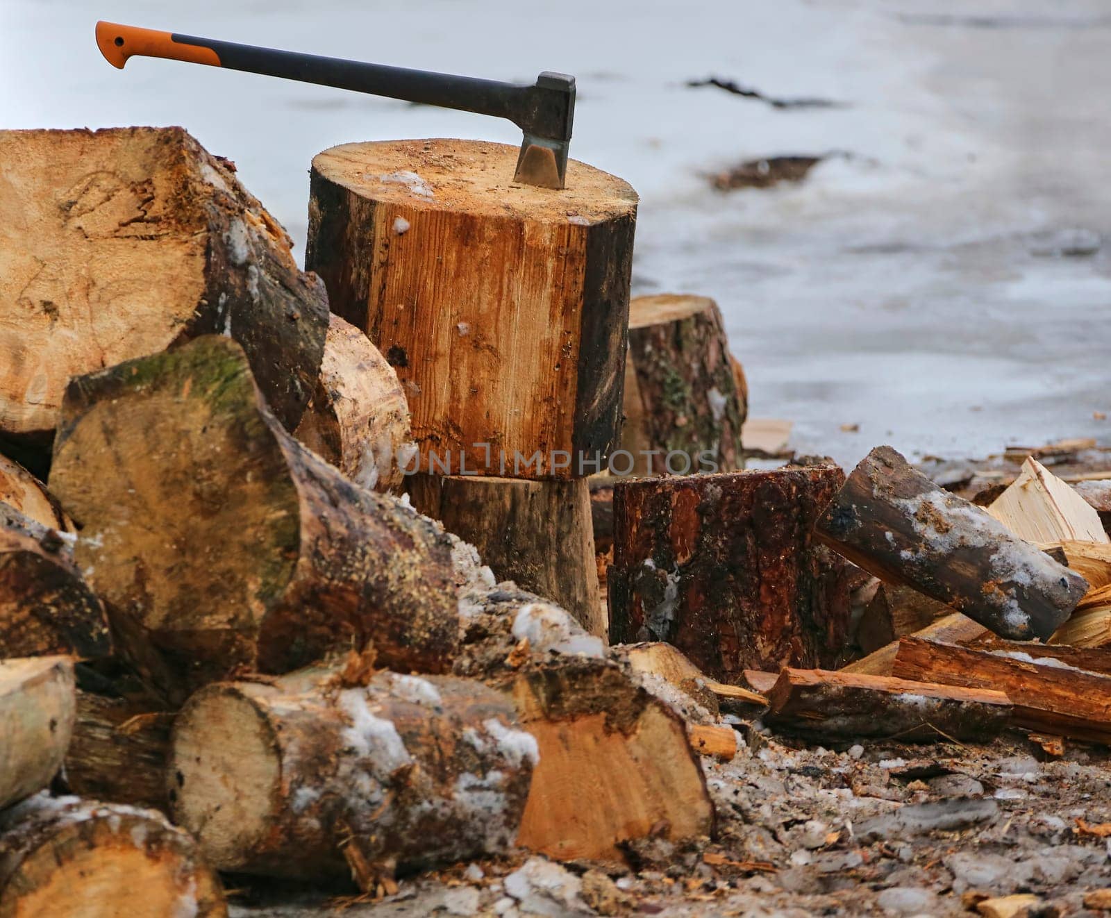 Old ax and a deck for chopping wood. Dry firewood, chopped wood for winter heating of the fireplace.