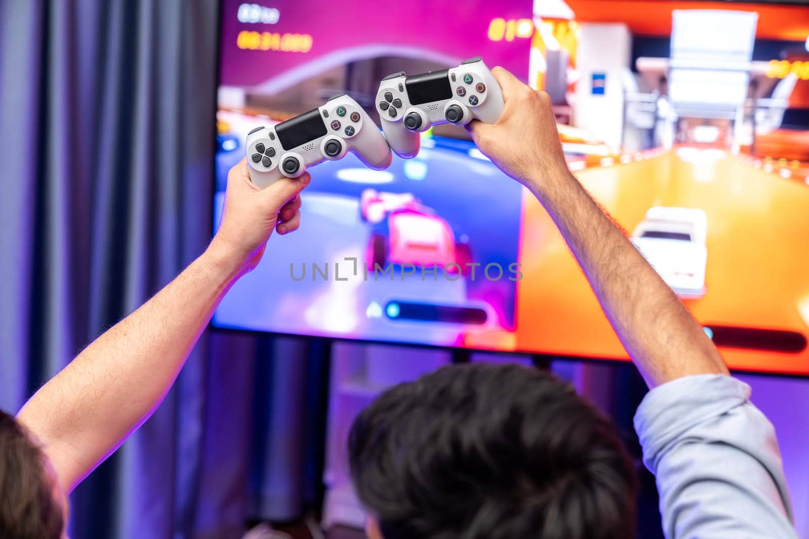 Close up photo of holding joystick crashing or cheerful friends on car racing competition of video game on blurred screen. Concept of lifestyles gamer on weekend with friend in living room. Sellable.